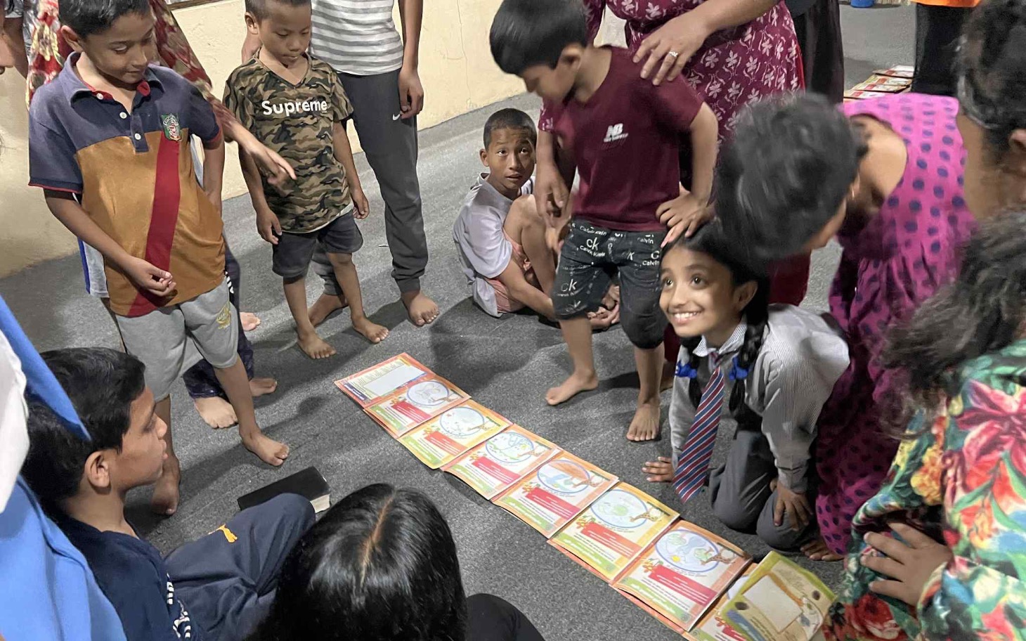 
        Dzieci bawiące się w grupie, grając w planszówkę.
    