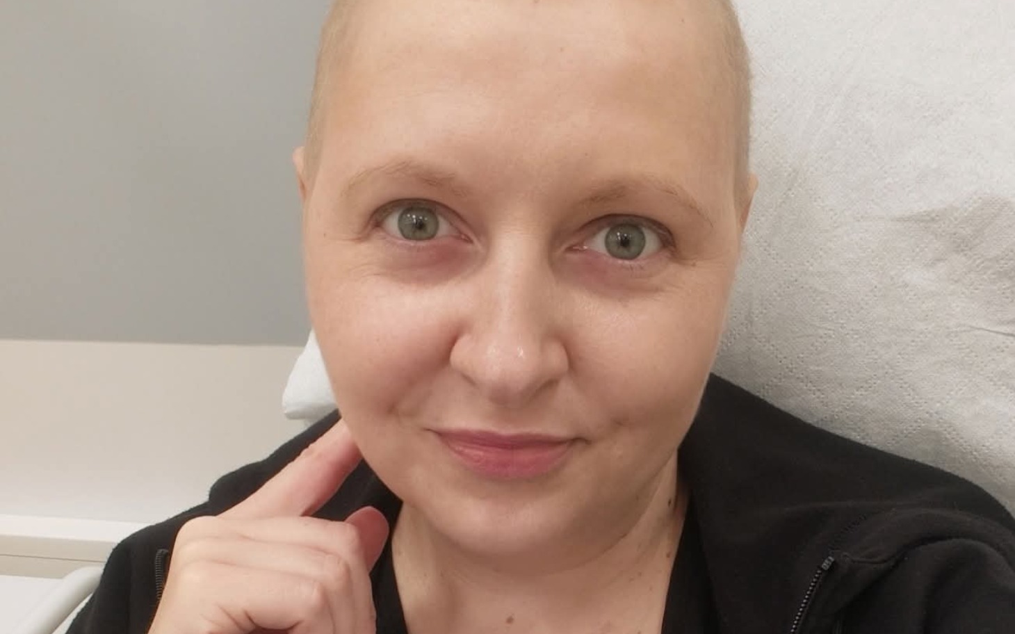 
        Kobieta z krótkimi włosami uśmiecha się do kamery.
    