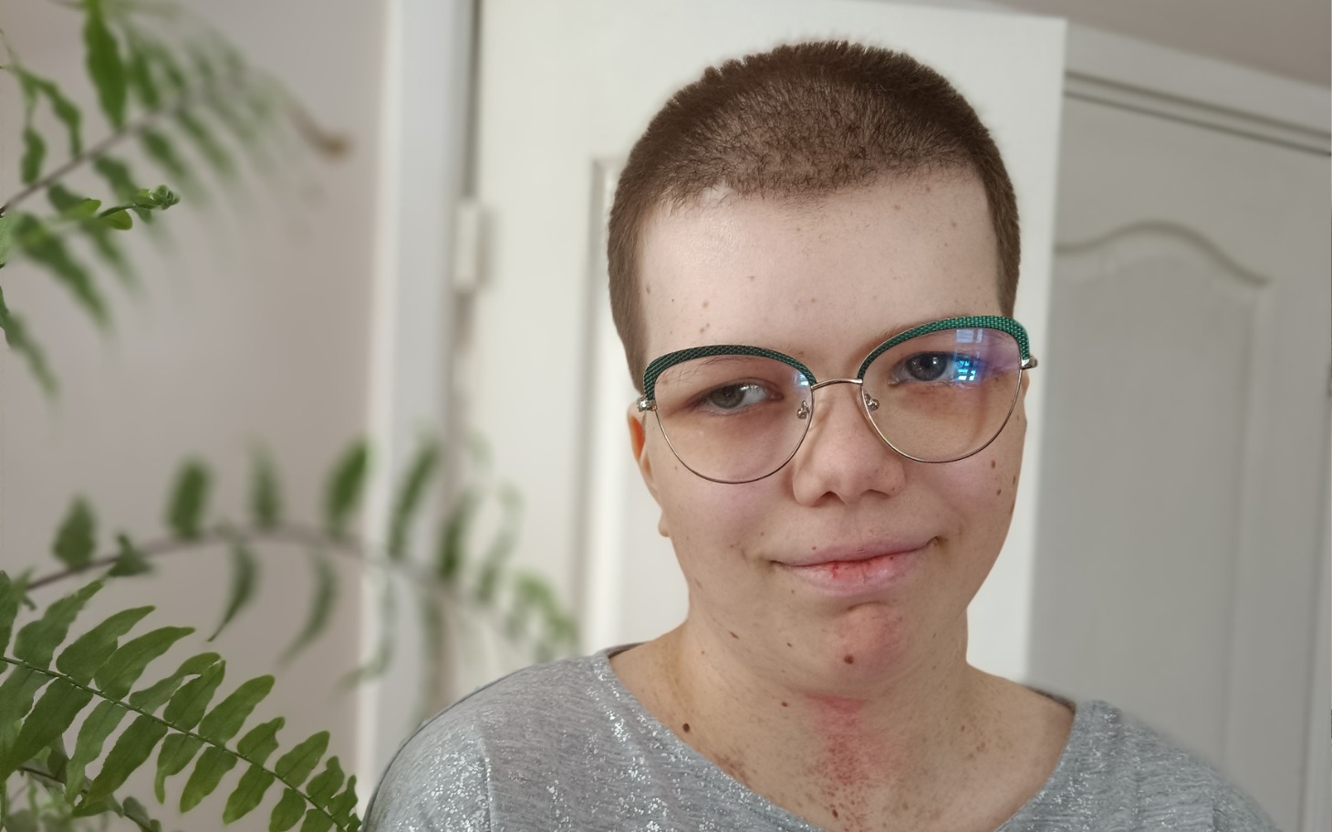 
        Młoda osoba z krótkimi włosami, uśmiechająca się do kamery.
    