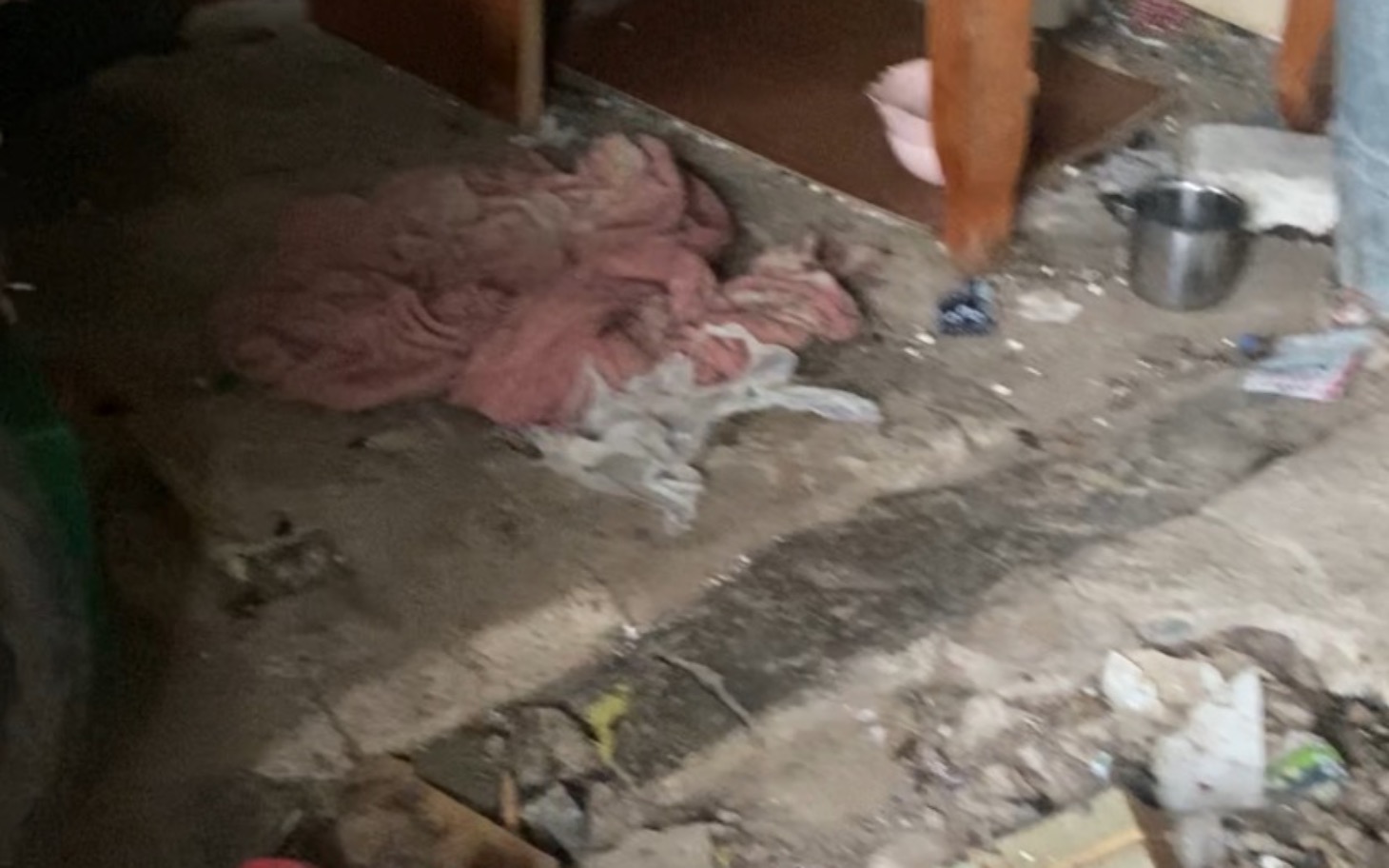 
        Zabałaganione pomieszczenie z brudnymi rzeczami na podłodze.
    