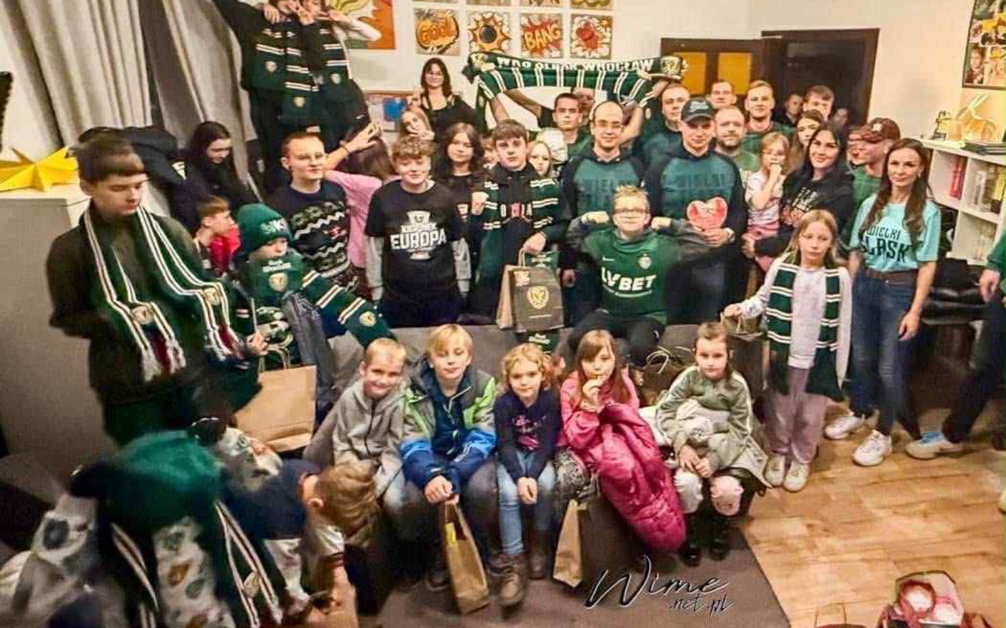 
        Grupa ludzi w zielonych koszulkach, wspólne zdjęcie.
    