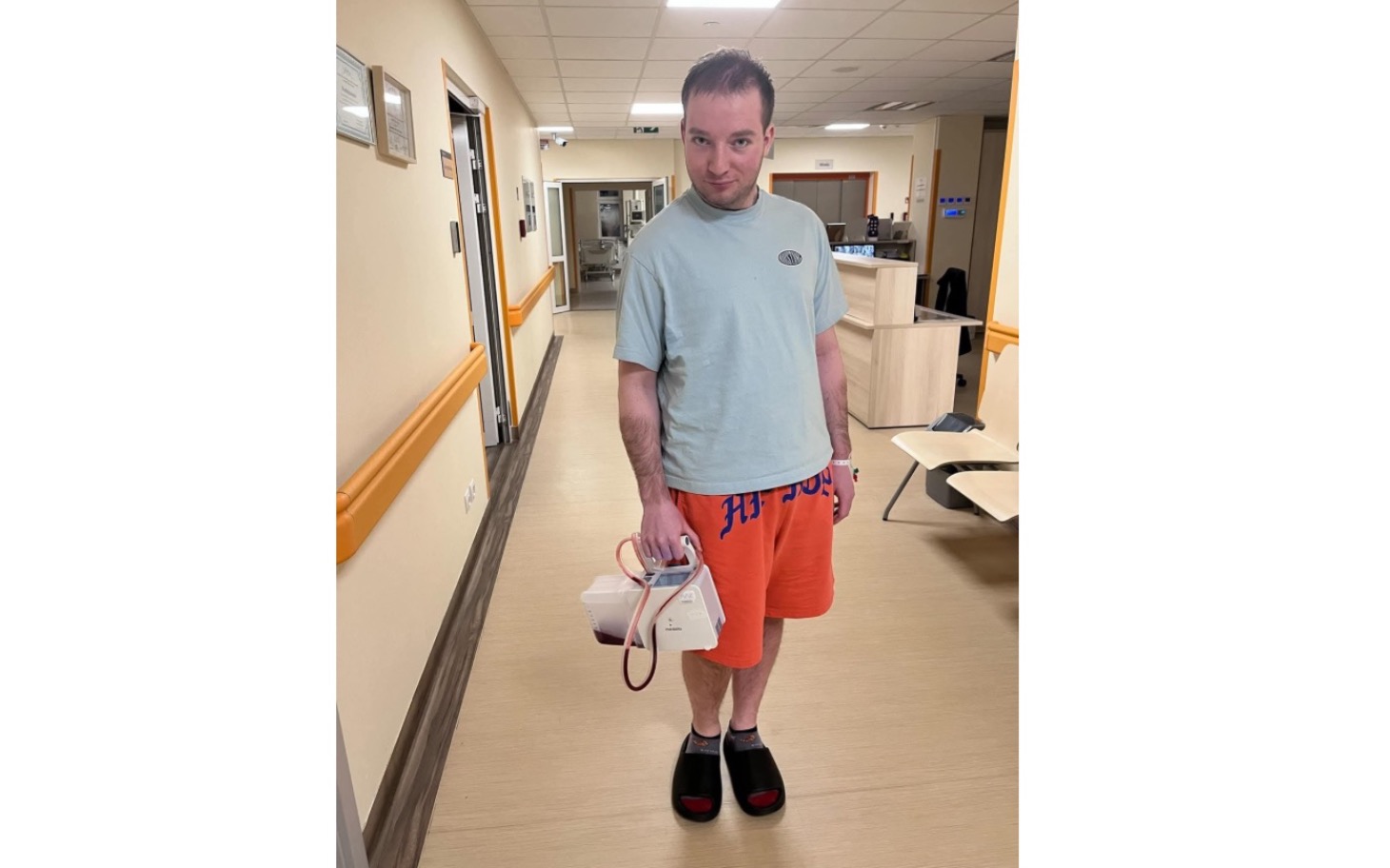 
        Mężczyzna w szpitalu, trzymający sprzęt medyczny.
    