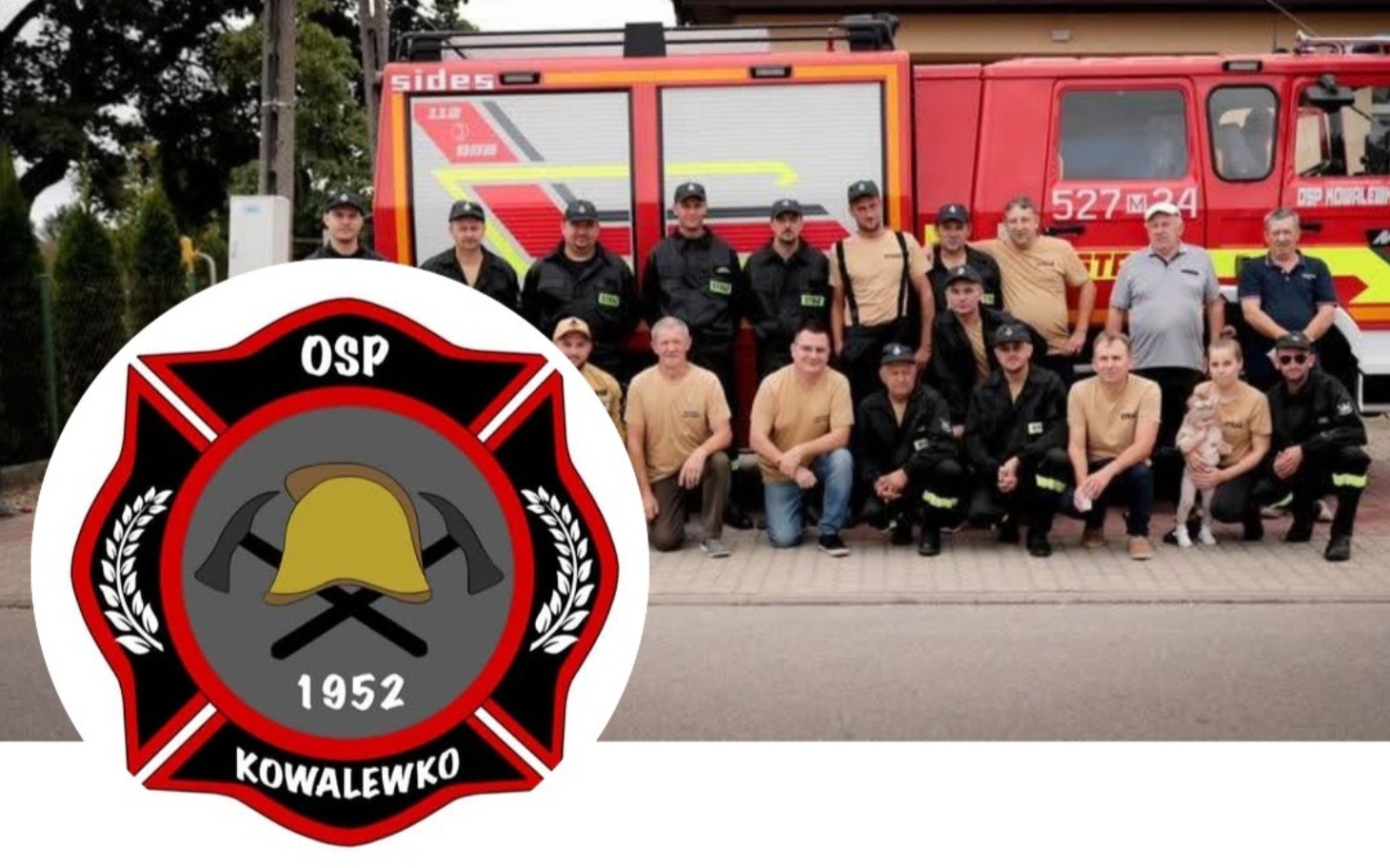 Grupa strażaków pozująca przed wozem strażackim.