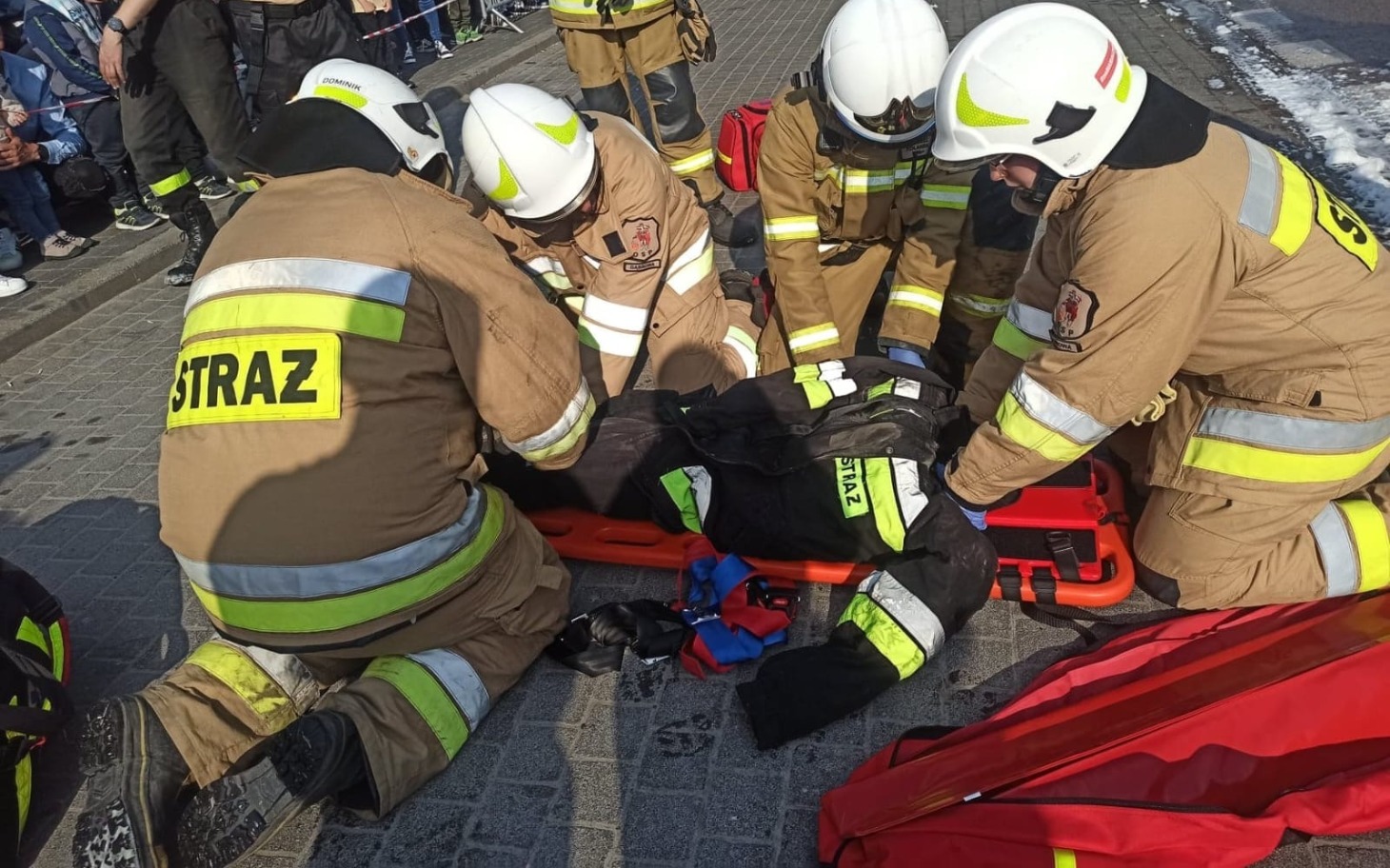 
        Strażacy udzielają pomocy poszkodowanemu na noszach.
    