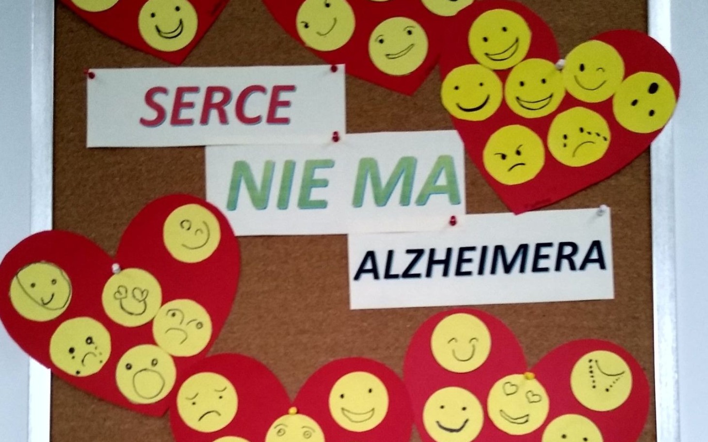 
        Tablica z sercami i emotikonami, hasło o Alzheimerze.
    