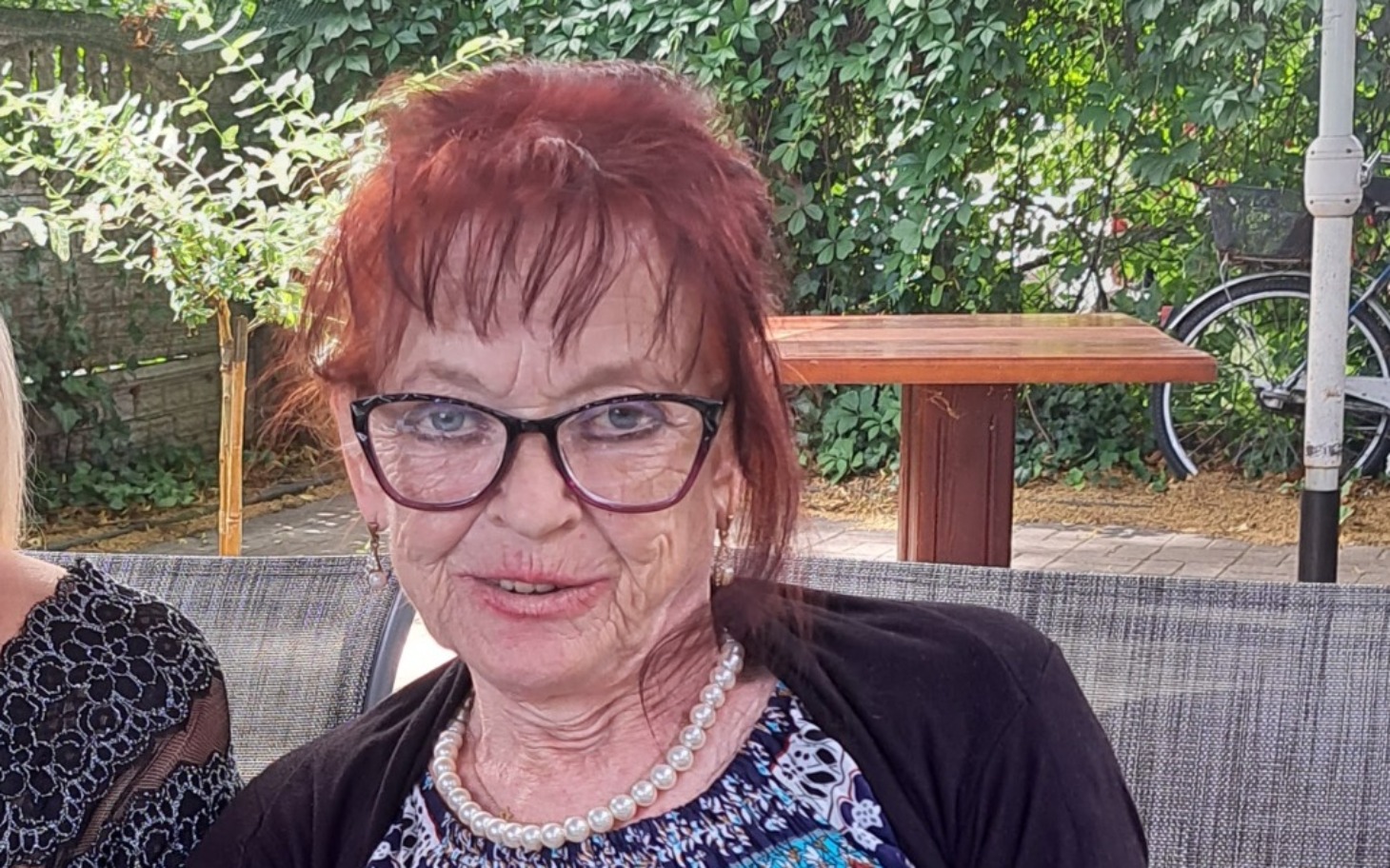 
        Starsza kobieta z czerwonymi włosami w okularach.
    