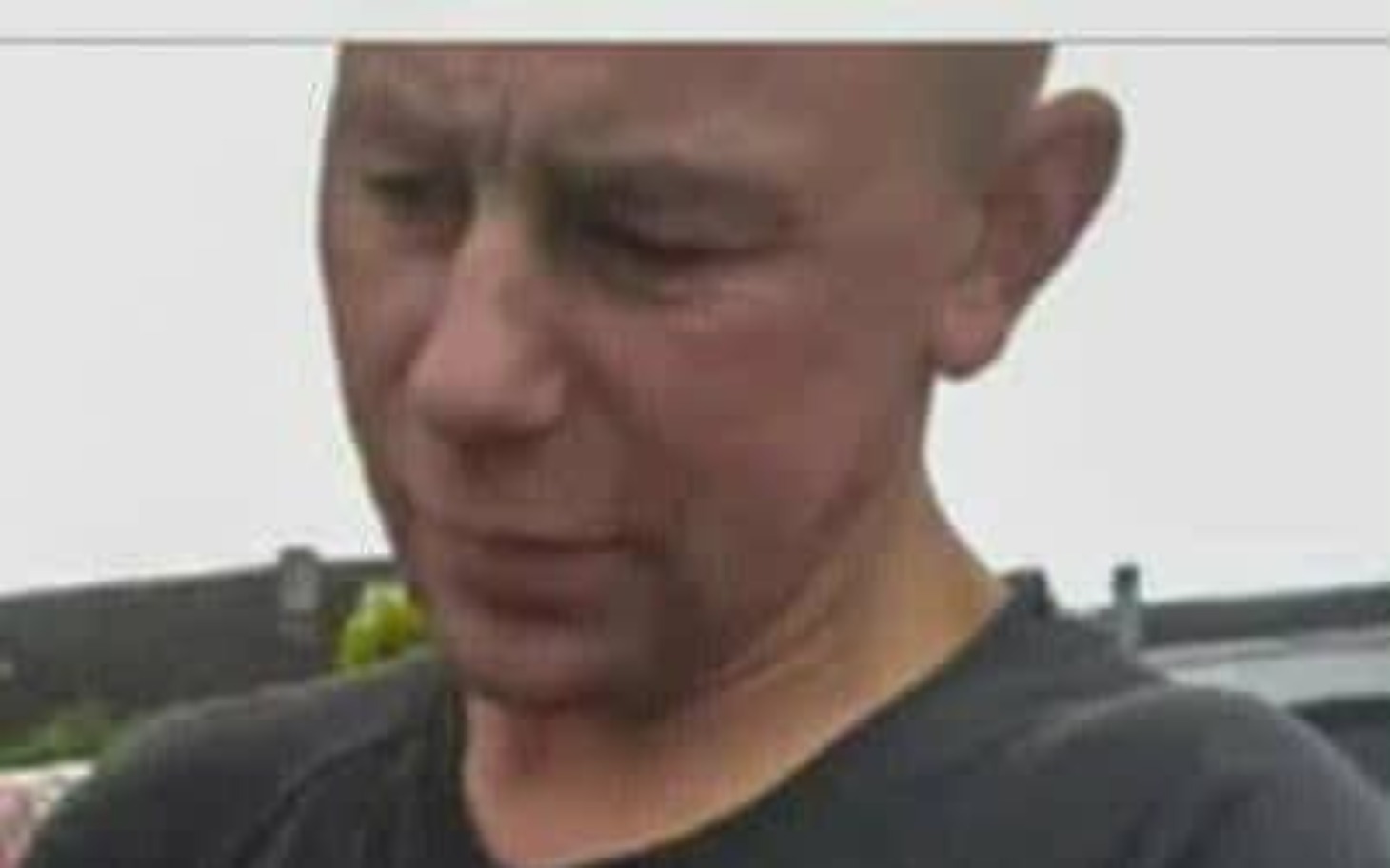 
        Mężczyzna z zamyśloną miną, patrzący w dół.
    