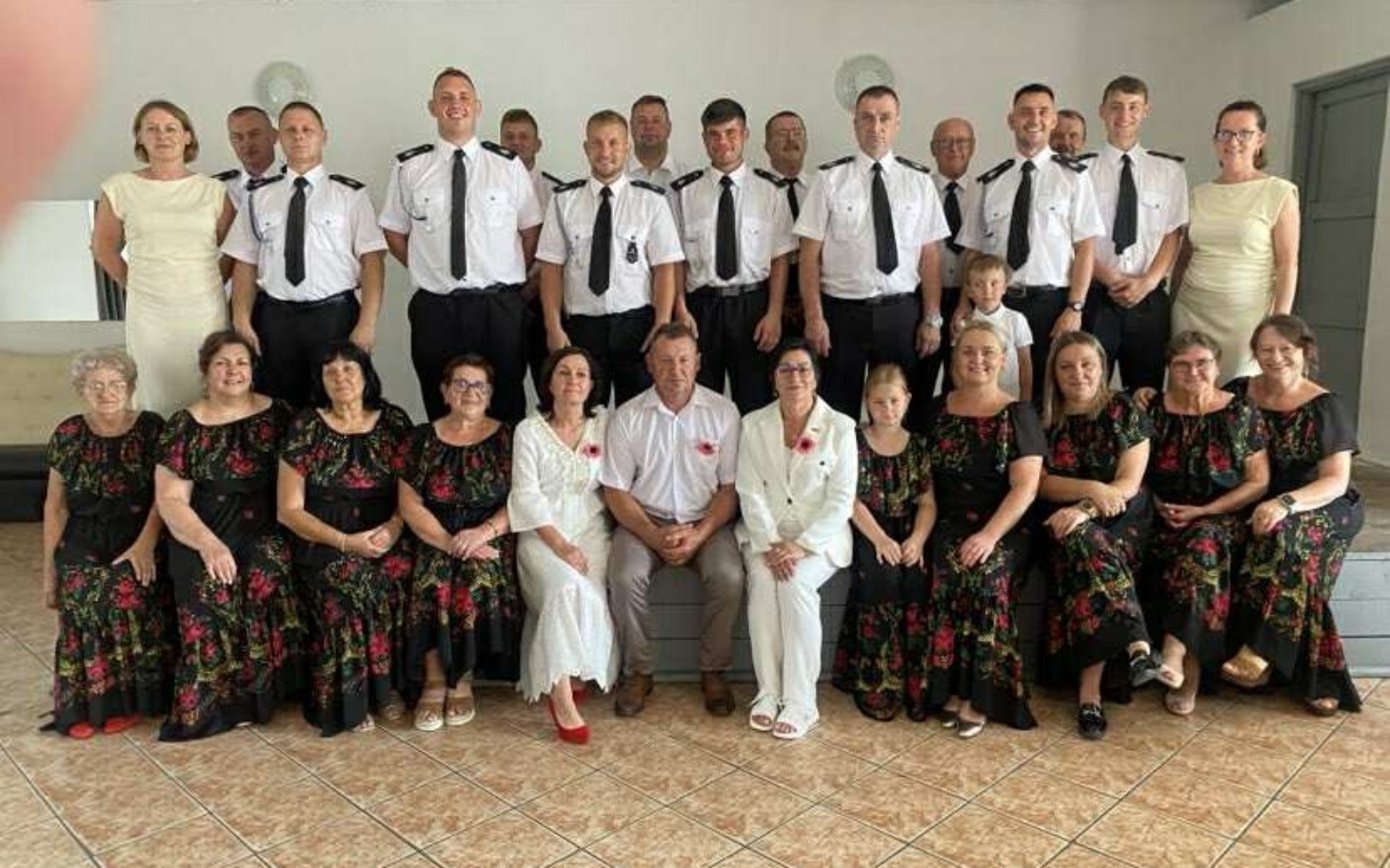 
        Grupa ludzi w strojach na uroczystości.
    