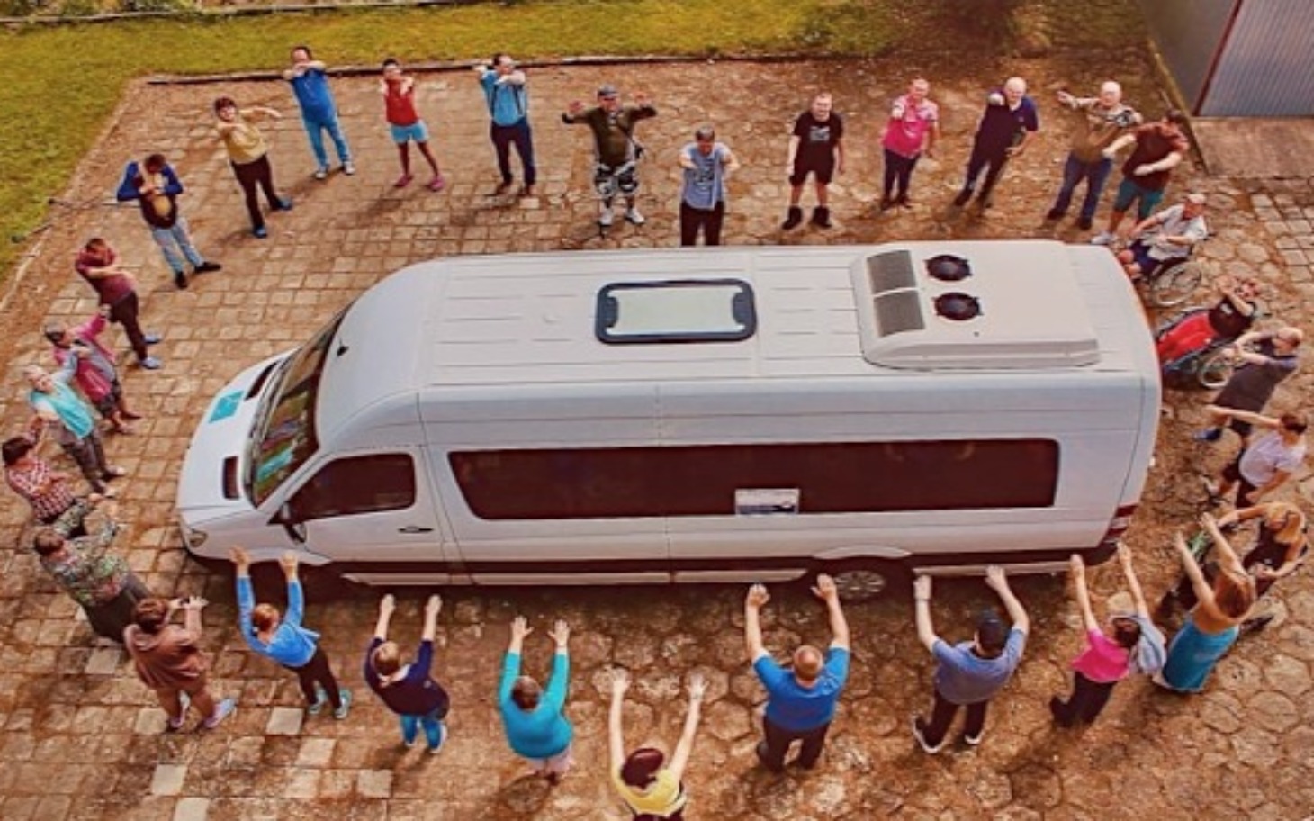 
        Grupa ludzi wokół busa, wspierających akcję.
    