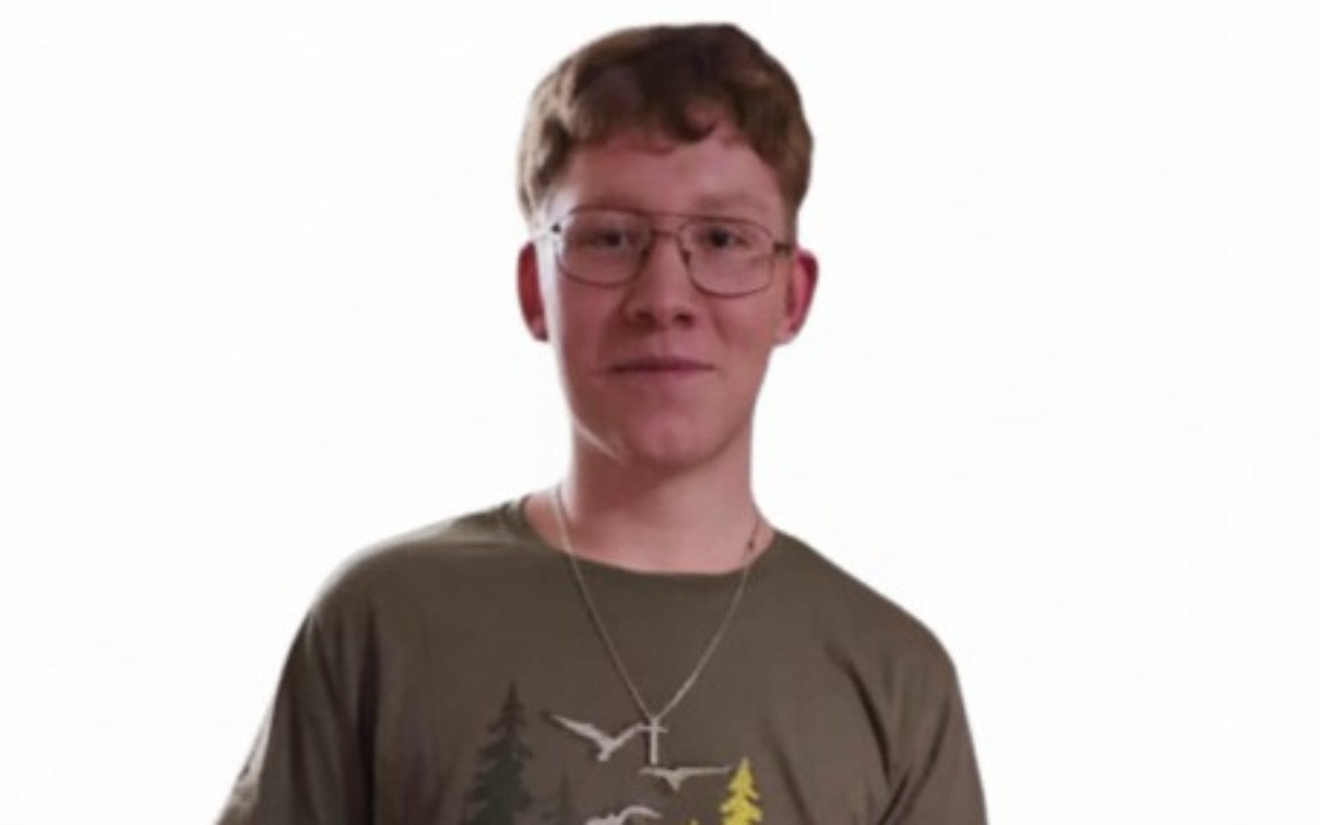 
        Młody mężczyzna w koszulce z nadrukiem, uśmiechający się do kamery.
    