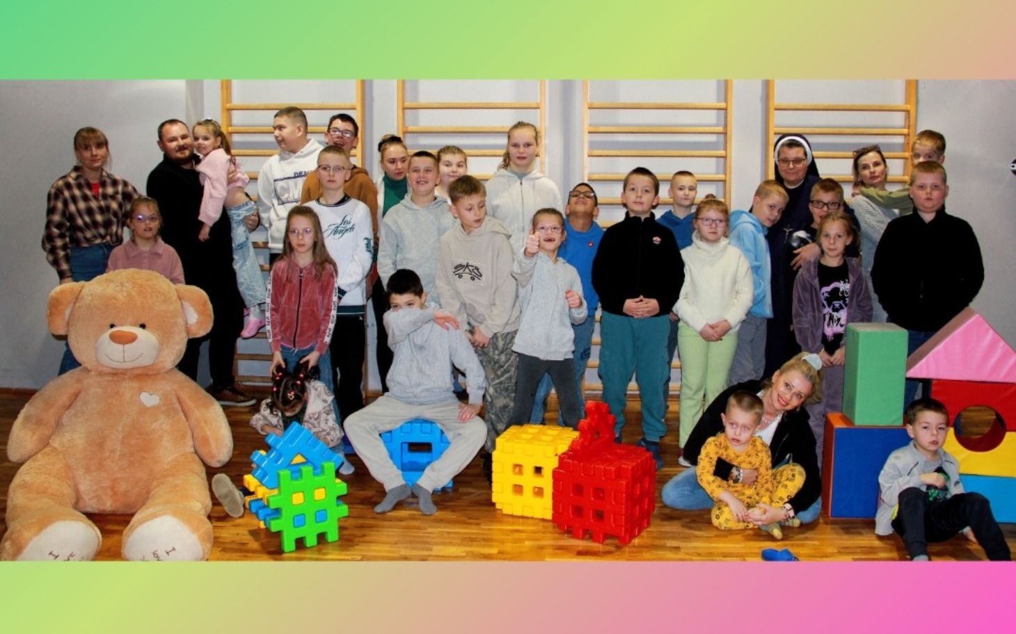 
        Grupa dzieci bawiących się w sali z kolorowymi zabawkami.
    