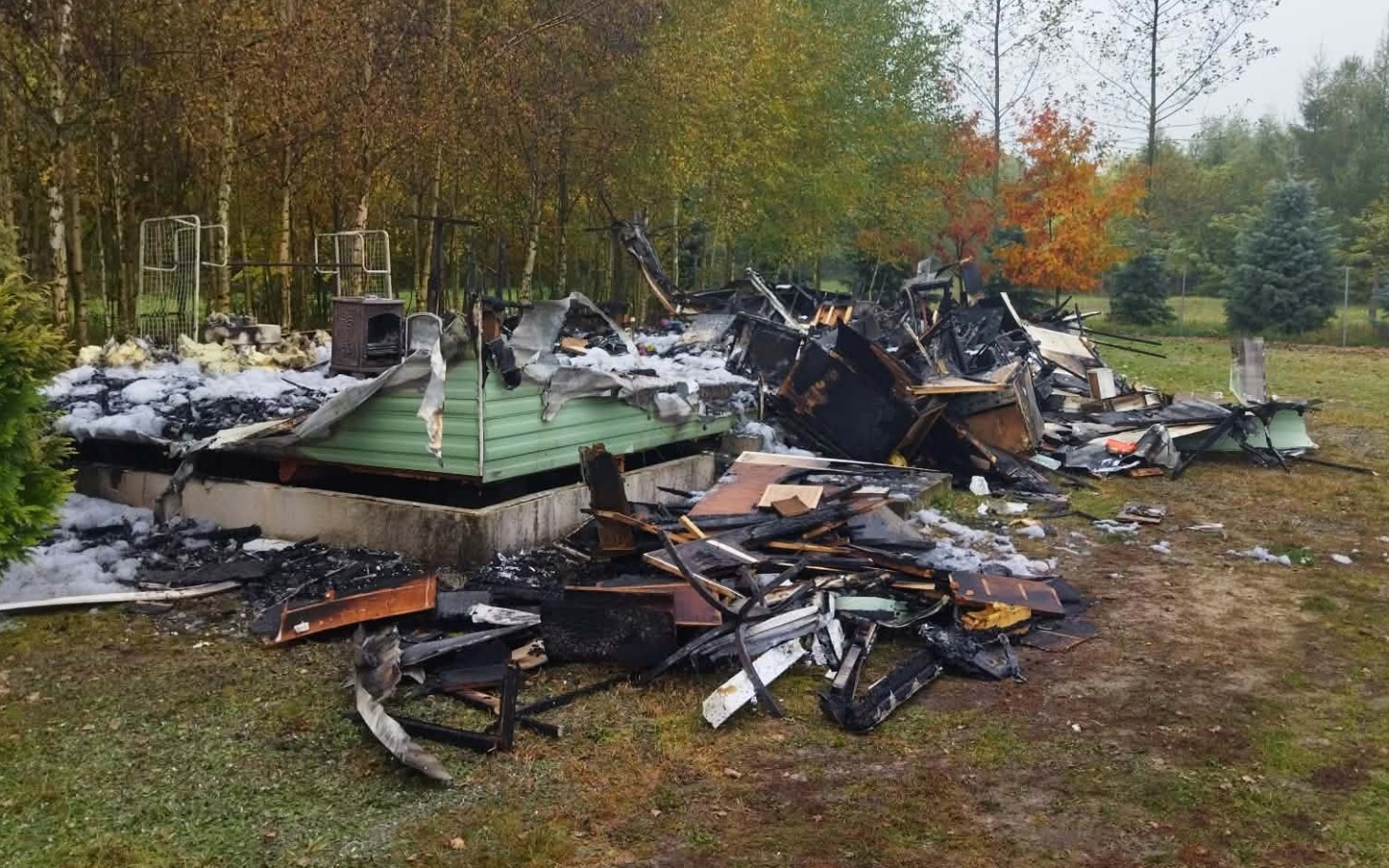 
        Zniszczony przez pożar budynek w otoczeniu jesiennego lasu
    