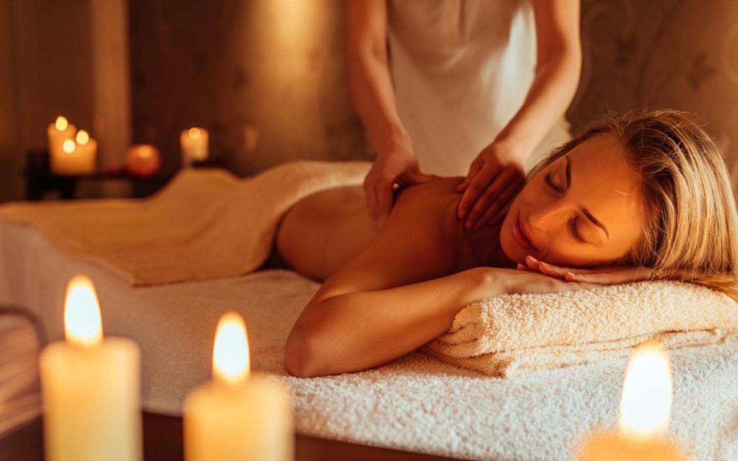 
        Relaksujący masaż w przytulnym spa z świecami.
    