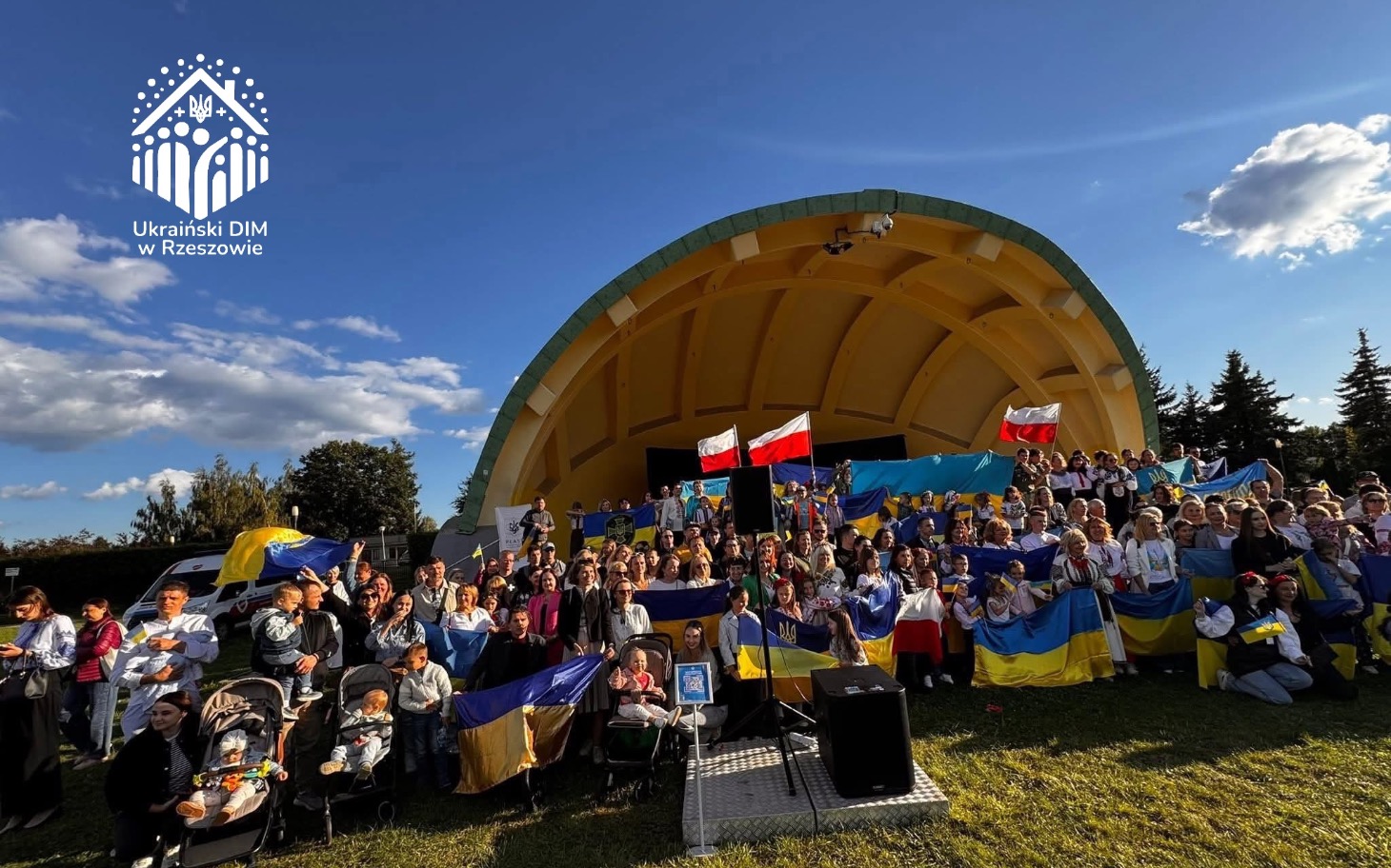 
        Grupa ludzi z flagami Ukrainy i Polski na wydarzeniu.
    