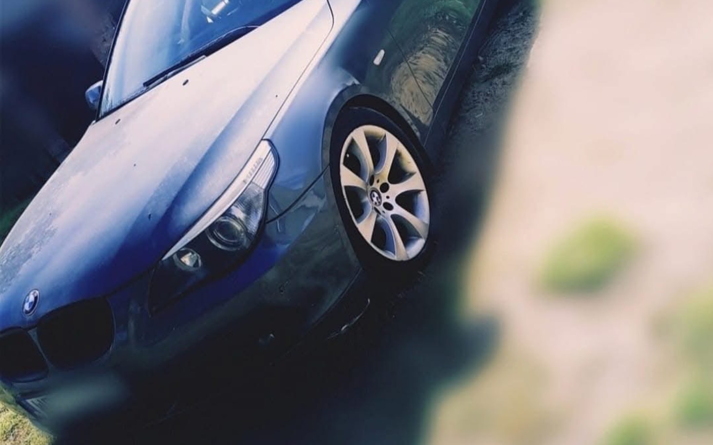 
        Czarny samochód zaparkowany na trawie.
    