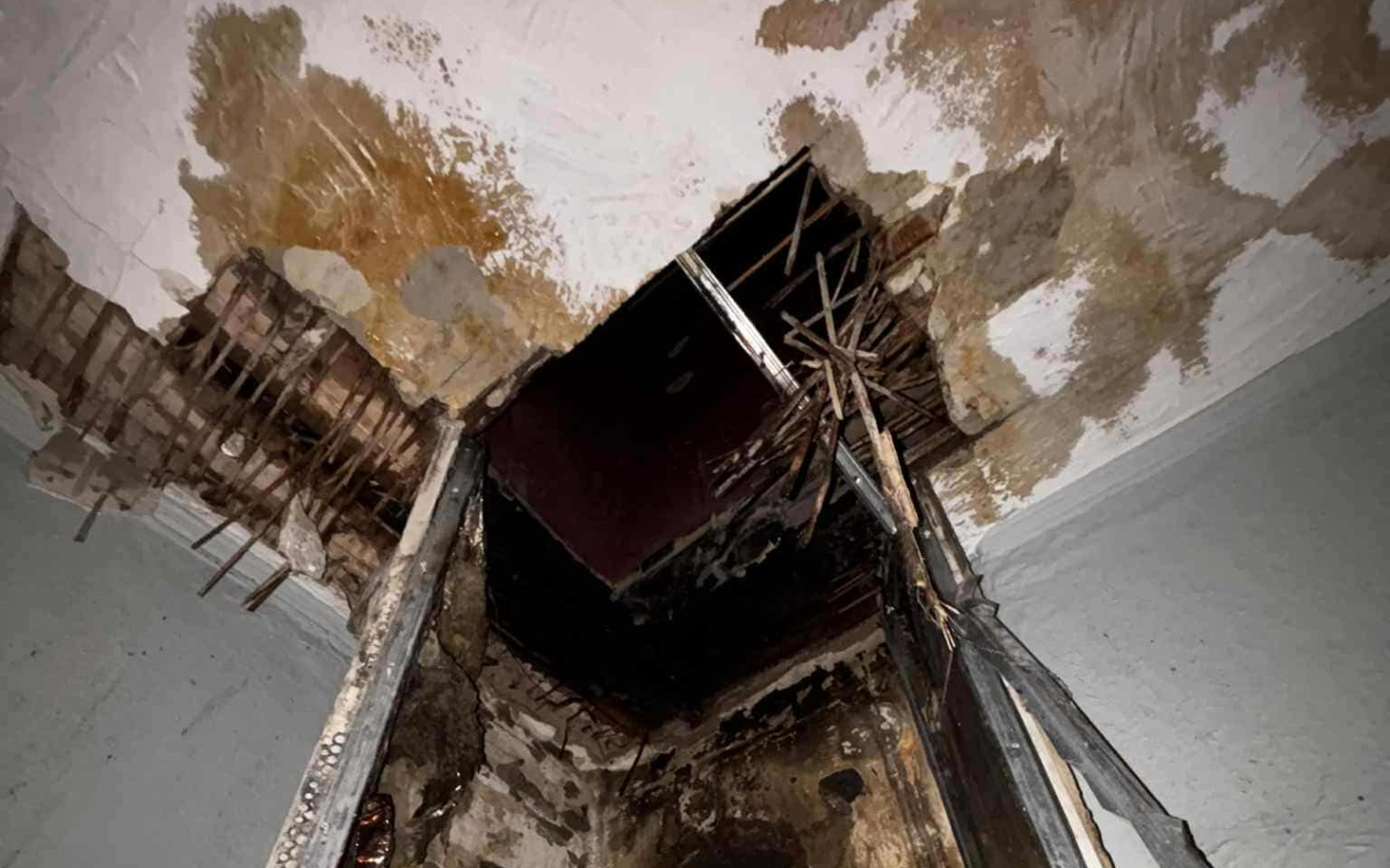 
        Zniszczony sufit z widocznymi śladami po pożarze.
    