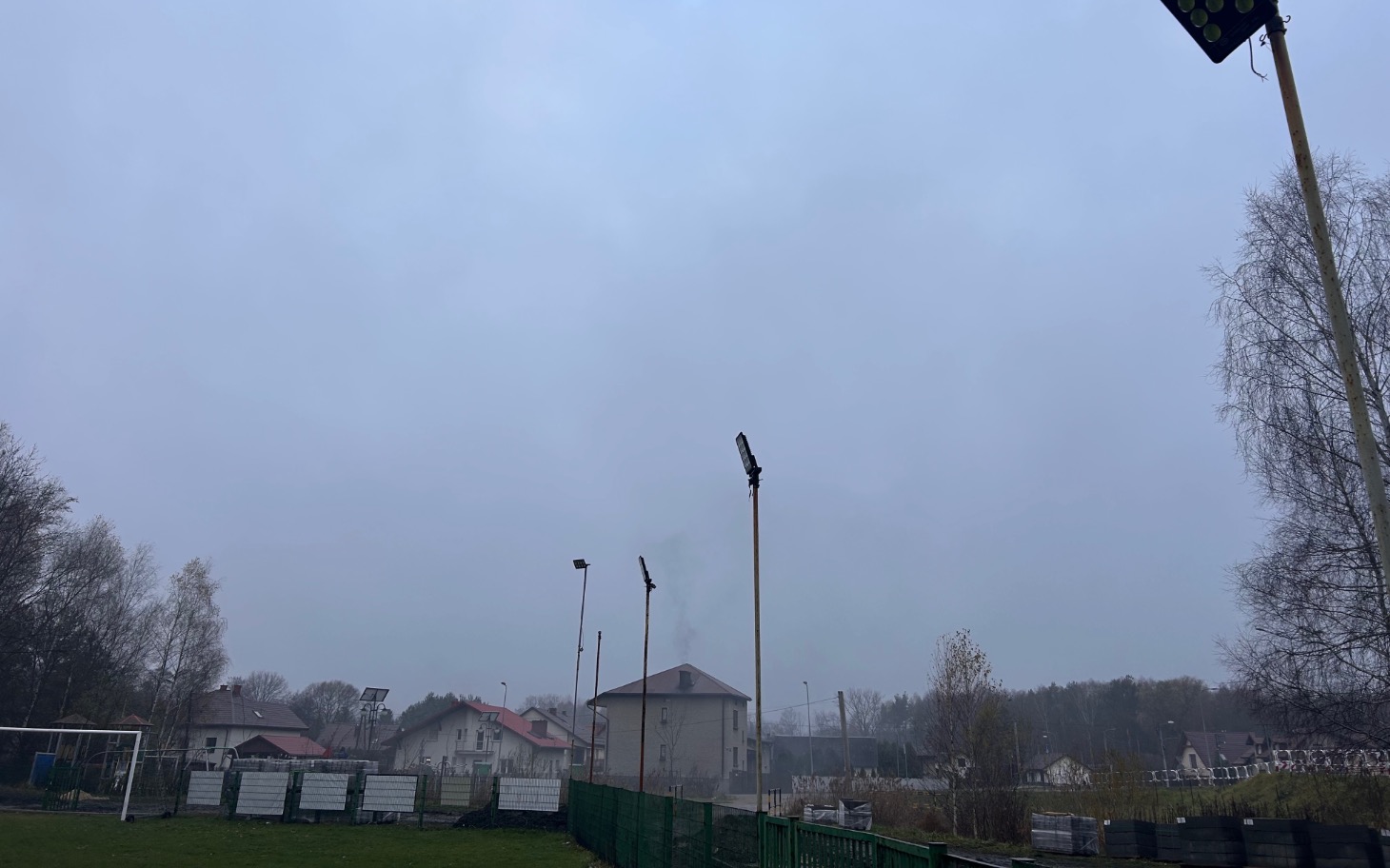 
        Widok na szare niebo nad boiskami sportowymi.
    