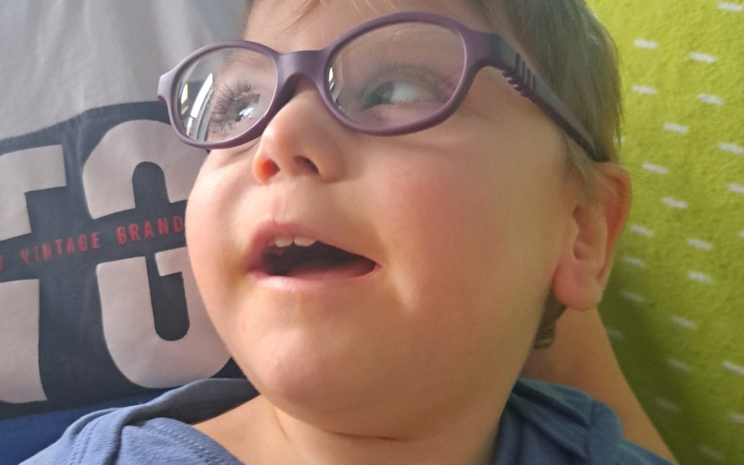 
        Chłopiec w okularach, uśmiecha się i wygląda na szczęśliwego.
    