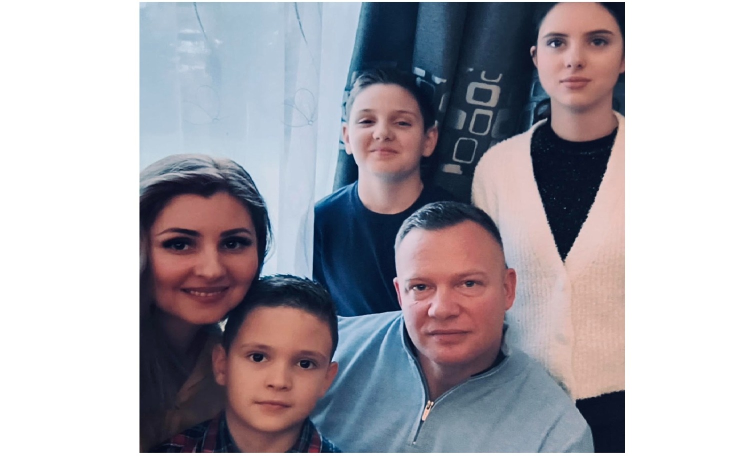 
        Rodzina pozująca do zdjęcia w przytulnym wnętrzu.
    