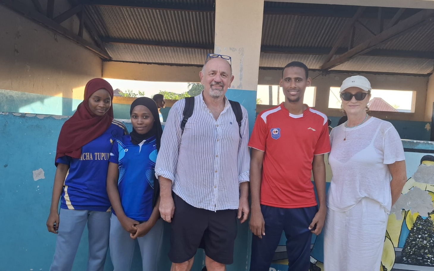 
        Grupa ludzi pozująca do zdjęcia w plenerze.
    