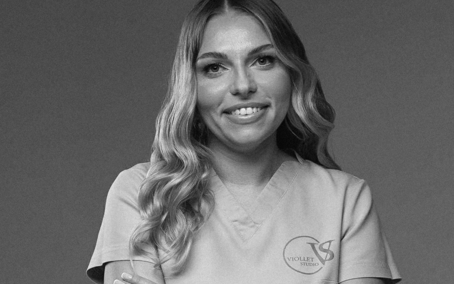 
        Kobieta w uniformie medycznym z uśmiechem.
    