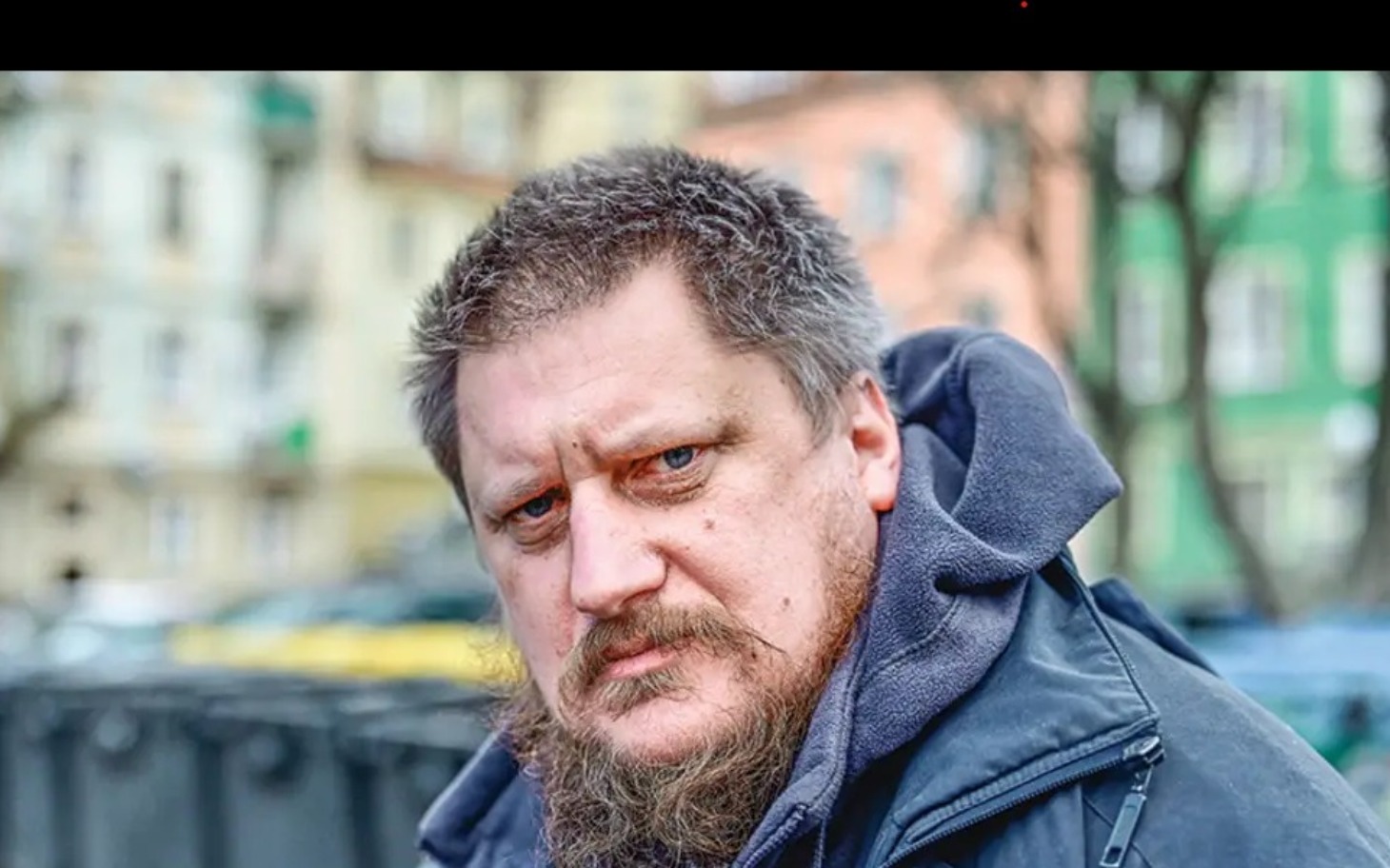 
        Mężczyzna z brodą, patrzący intensywnie w obiektyw.
    