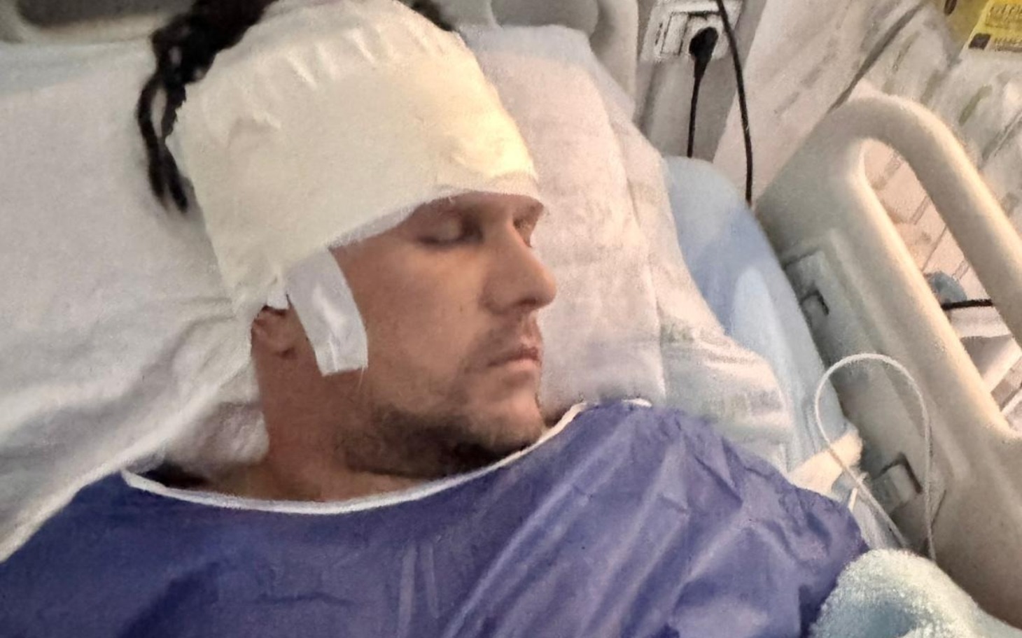 
        Mężczyzna w szpitalu, z opatrunkiem na głowie.
    