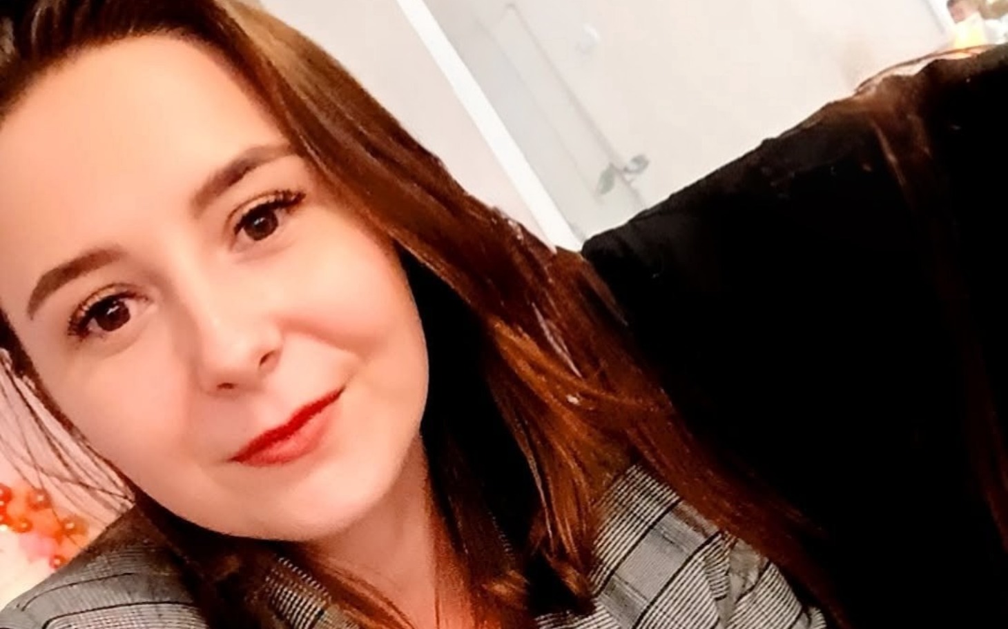 
        Portret młodej kobiety w eleganckim ubraniu, uśmiechającej się do kamery.
    