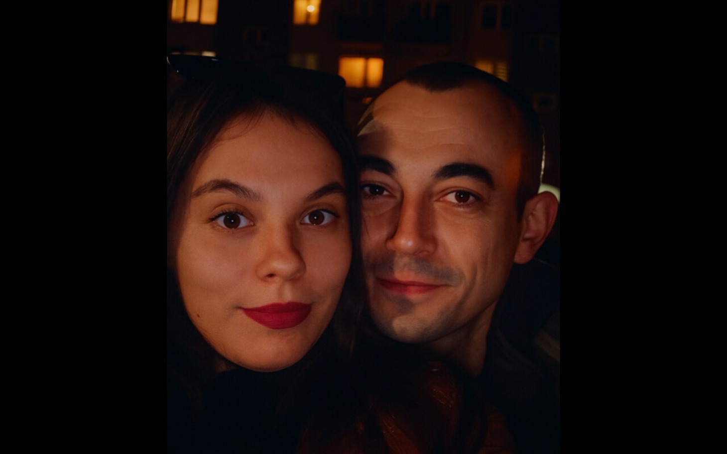 
        Para ludzi pozująca do zdjęcia, uśmiechnięta w nocy.
    