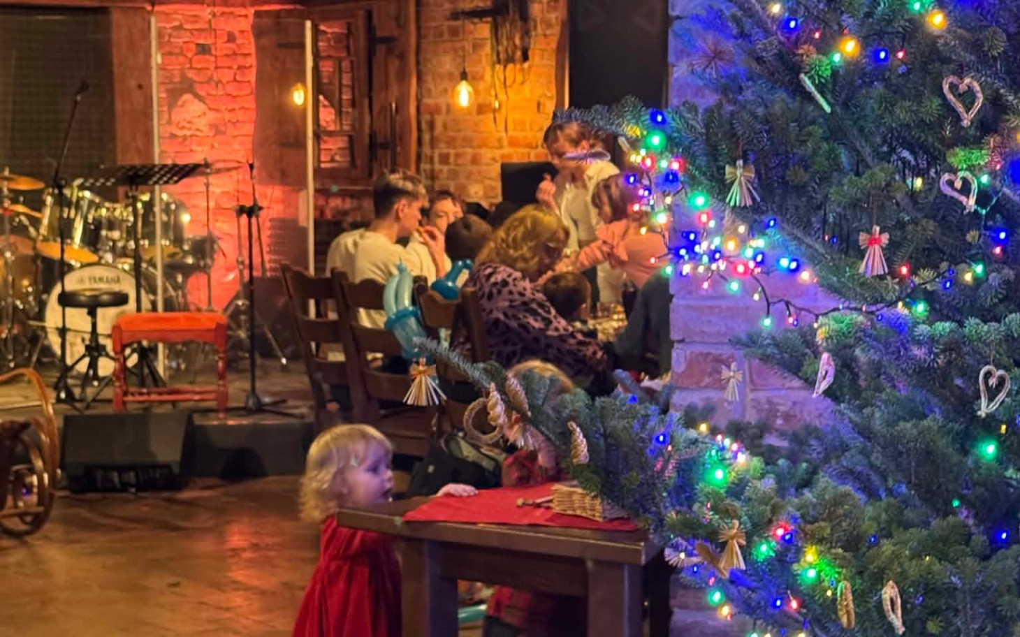 
        Świąteczne spotkanie z choinką i ludźmi w tle.
    