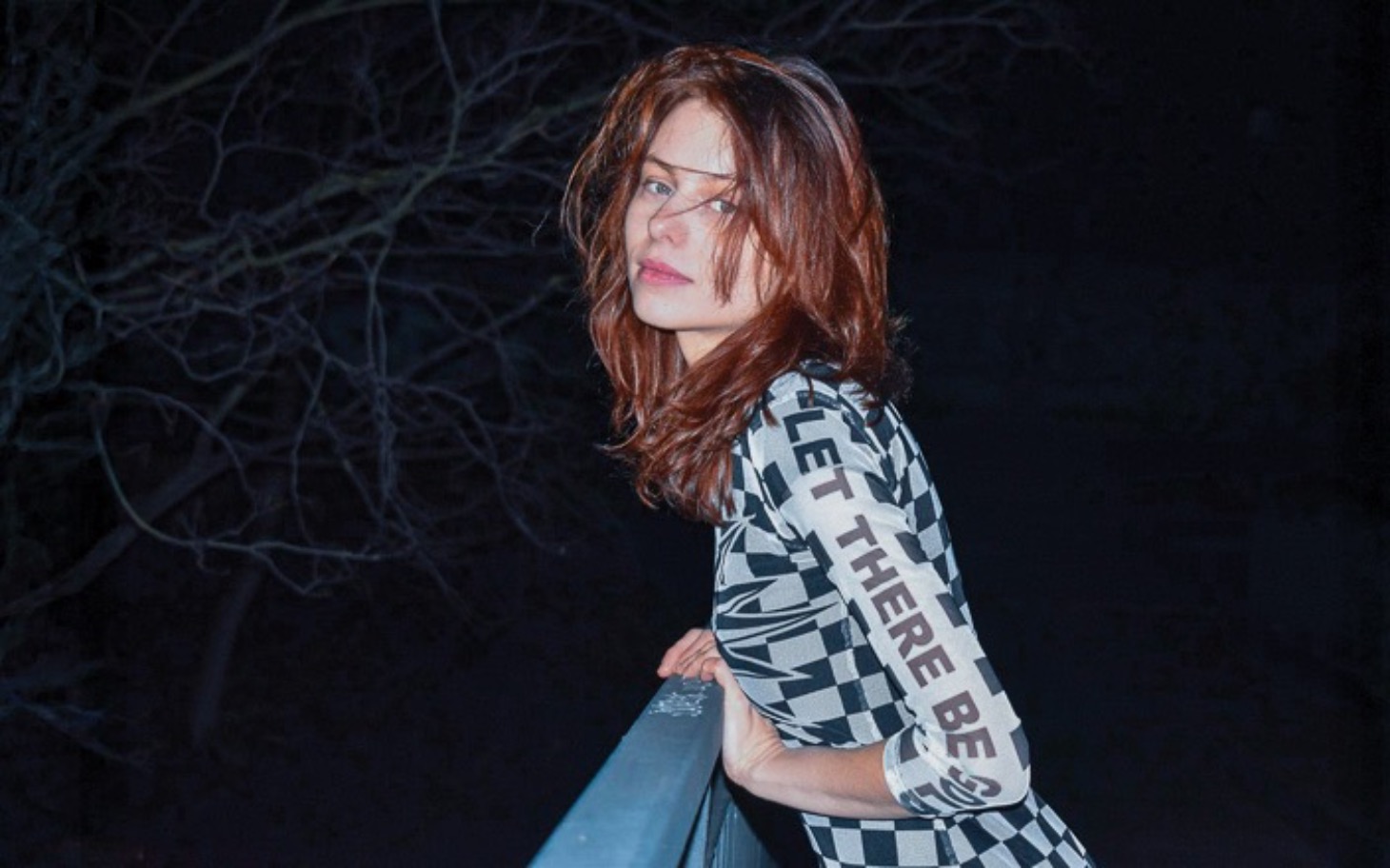 
        Kobieta w modnej sukience, pozująca w nocy.
    