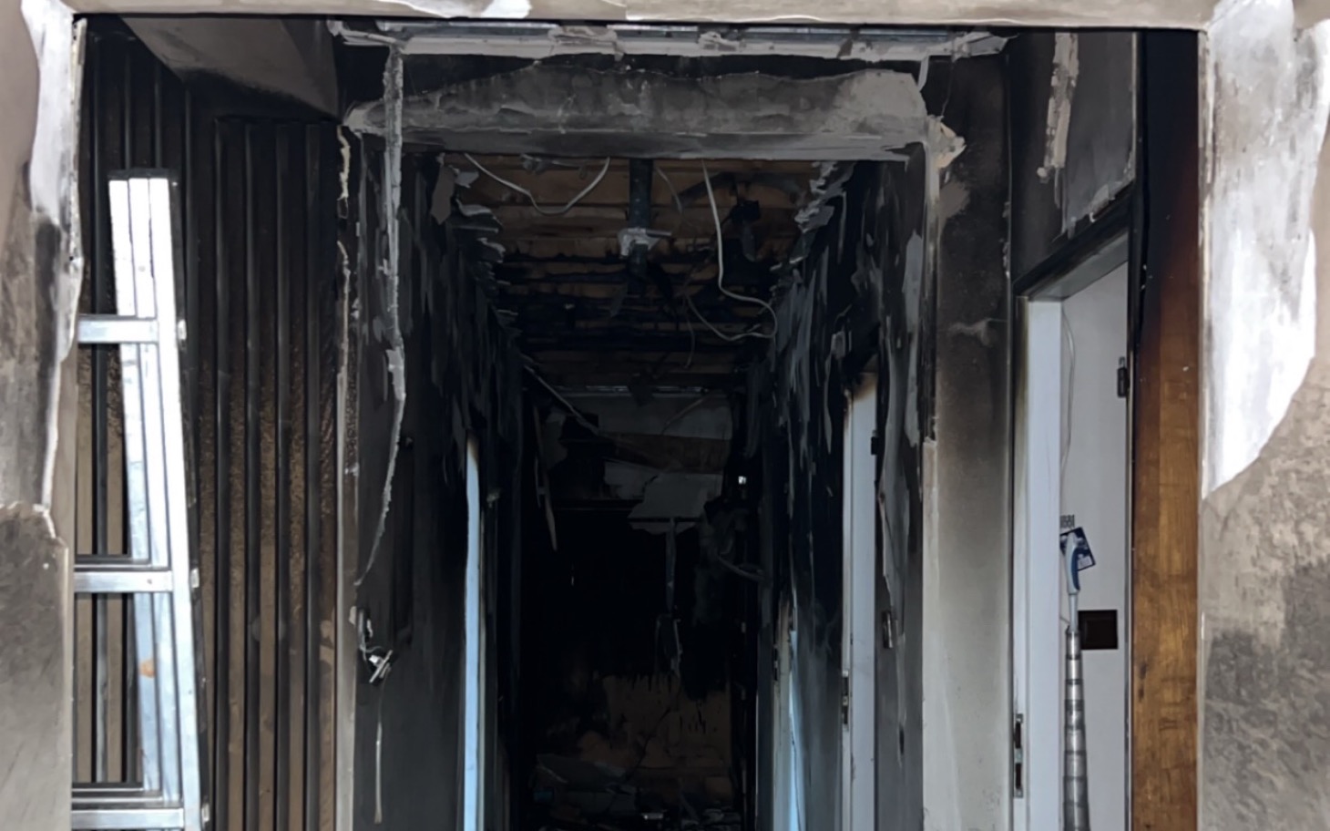 
        Zniszczony korytarz z widocznymi śladami po pożarze.
    