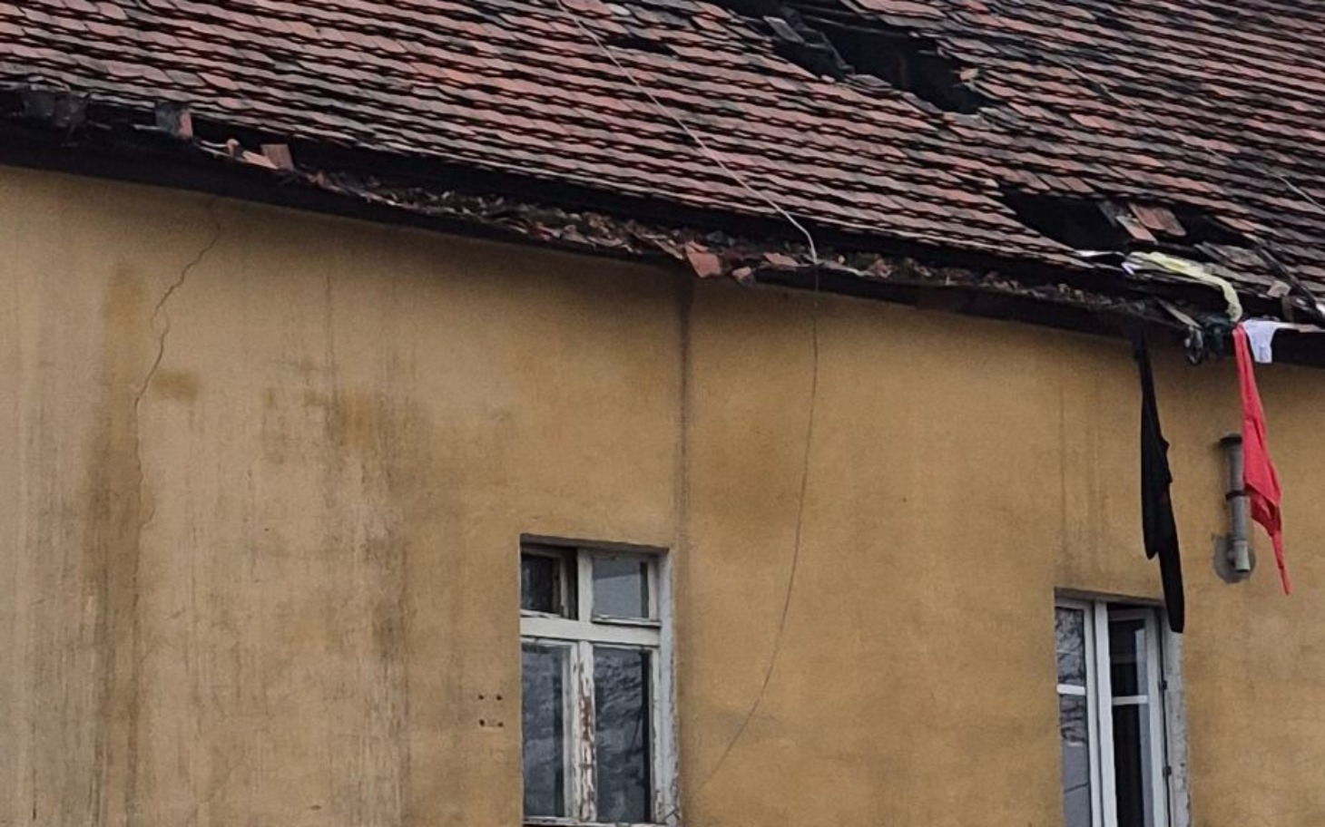 
        Zniszczony dach budynku, z widocznymi uszkodzeniami.
    