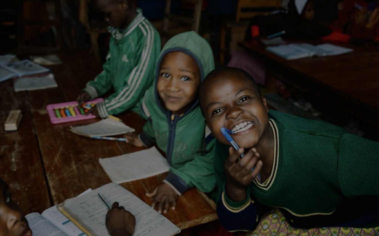 
        Dzieci w klasie, uśmiechnięte i zaangażowane w naukę.
    