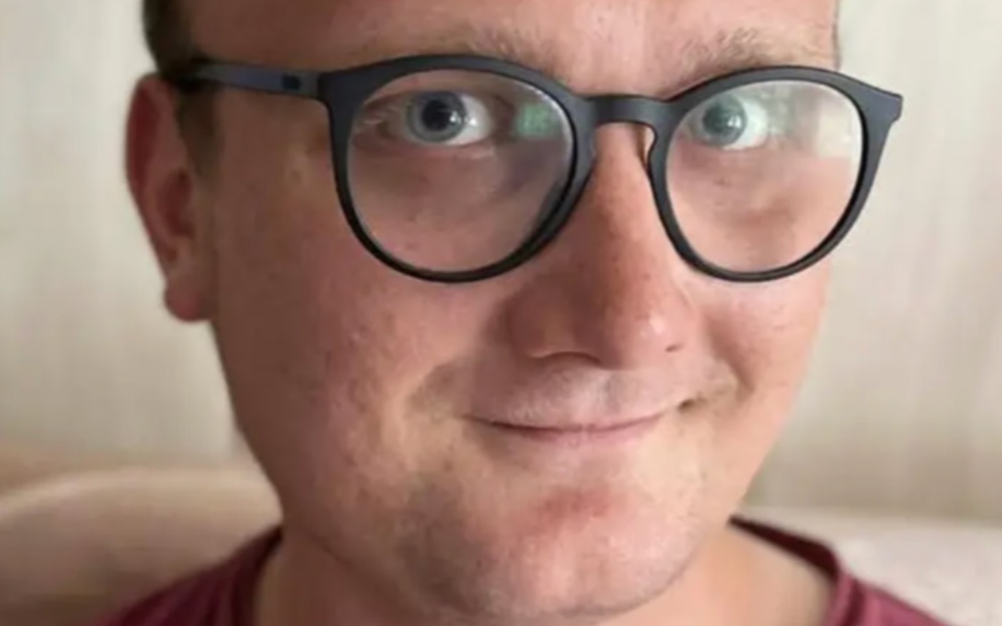 
        Mężczyzna w okularach, uśmiechający się do kamery.
    