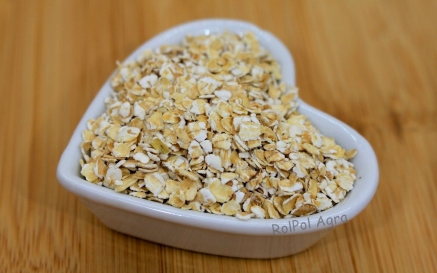 
        Płatki owsiane w sercowym naczyniu, gotowe do użycia.
    