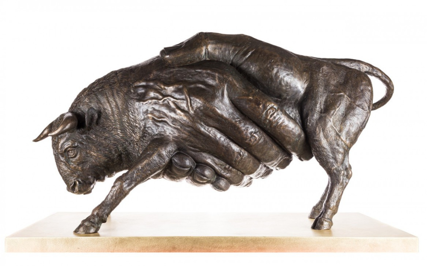 
        Rzeźba przedstawiająca byka trzymanego przez dłoń.
    