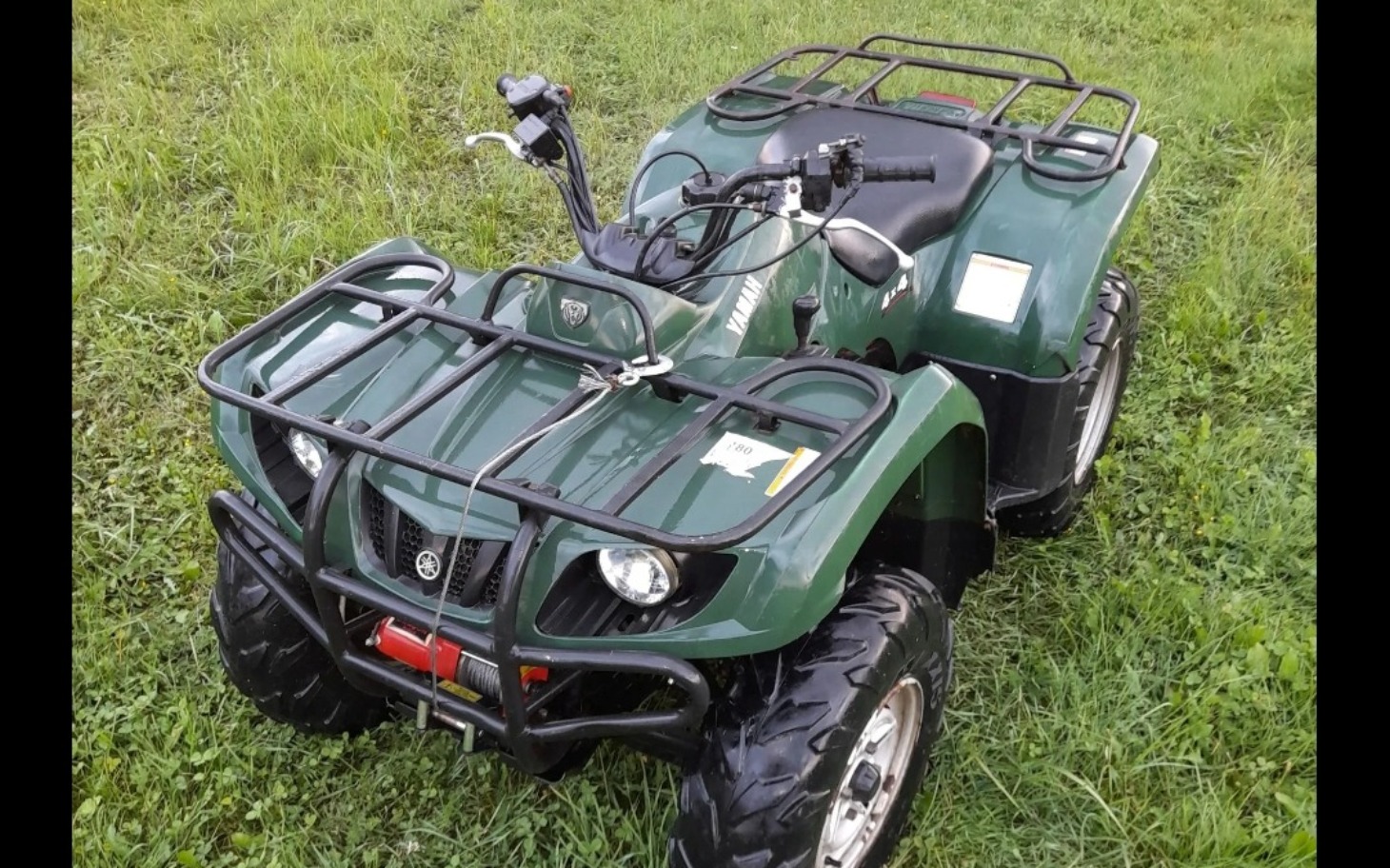
        Quadowy pojazd terenowy na zielonej łące.
    