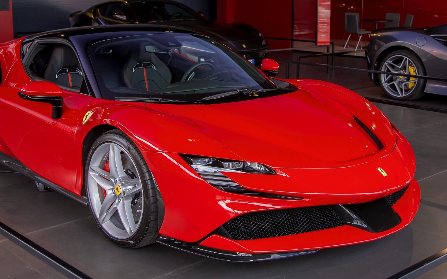 
        Czerwony samochód sportowy w nowoczesnym otoczeniu.
    