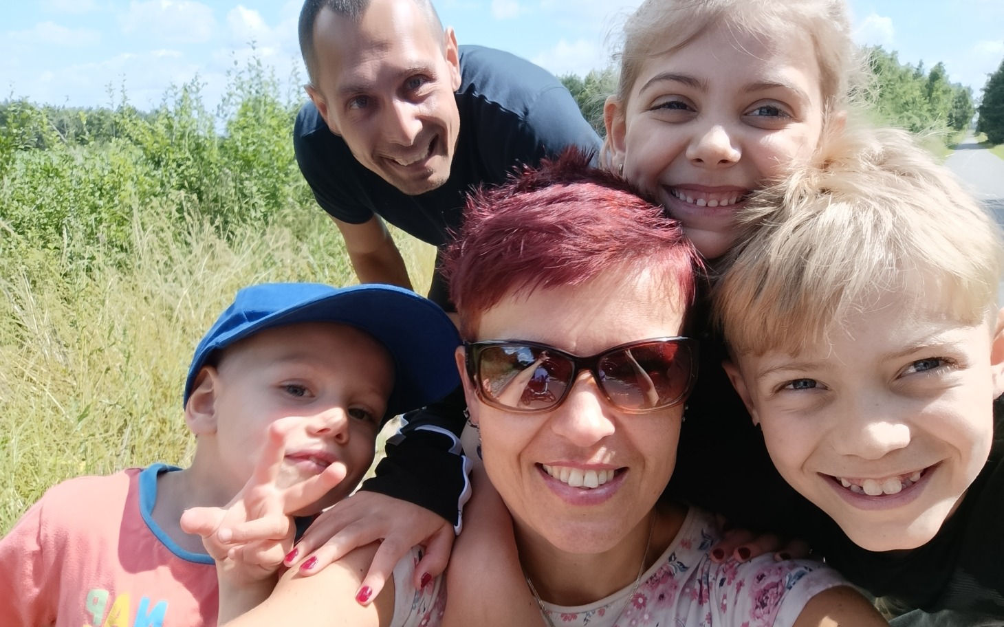 
        Rodzina uśmiechająca się na wspólnym zdjęciu.
    