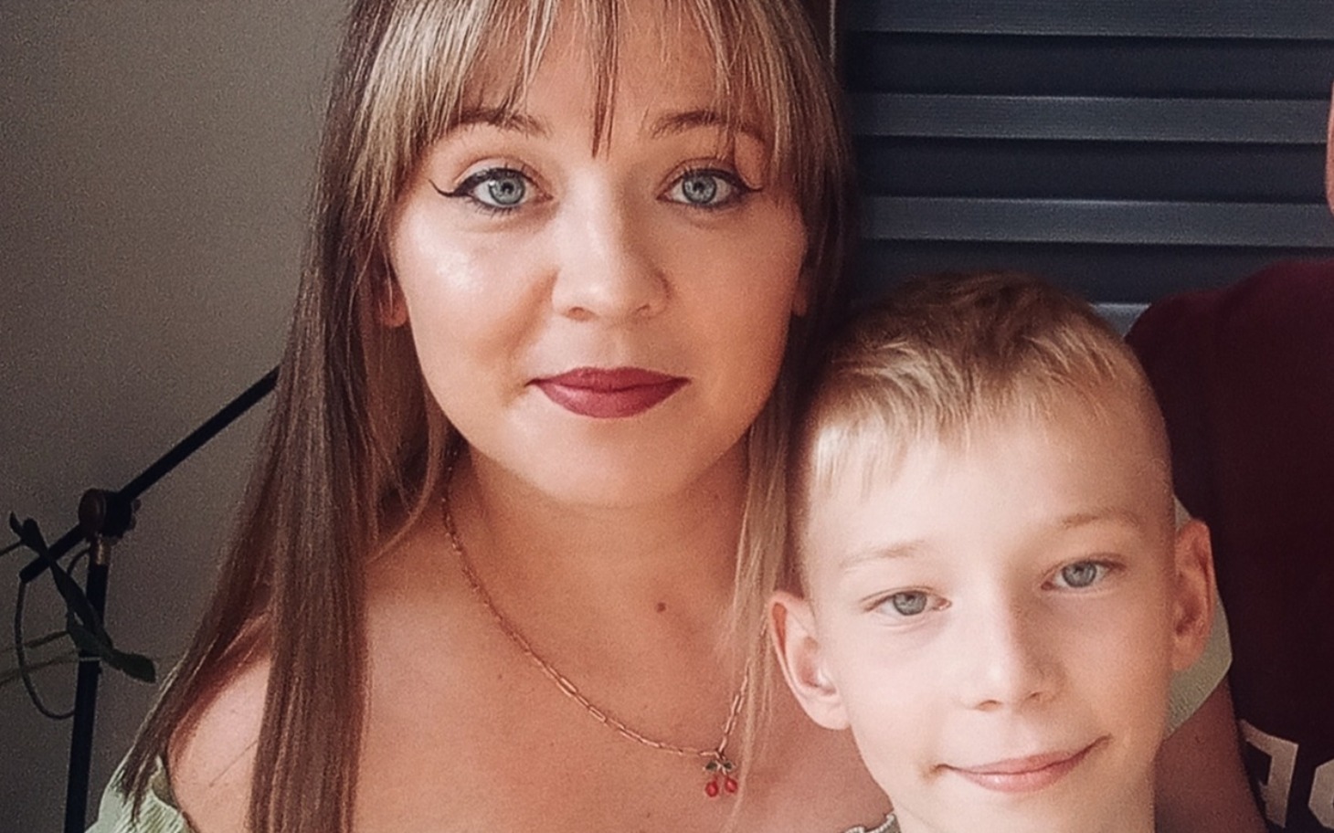 
        Portret matki z synem, oboje uśmiechnięci w domowym otoczeniu.
    