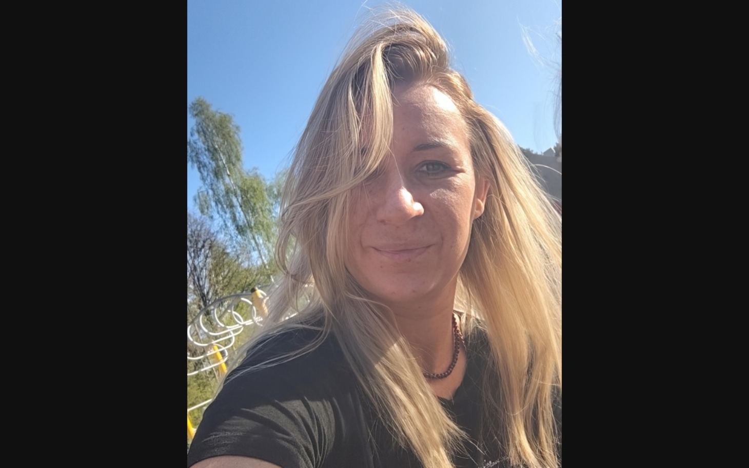 
        Kobieta z długimi włosami, uśmiechająca się do kamery.
    