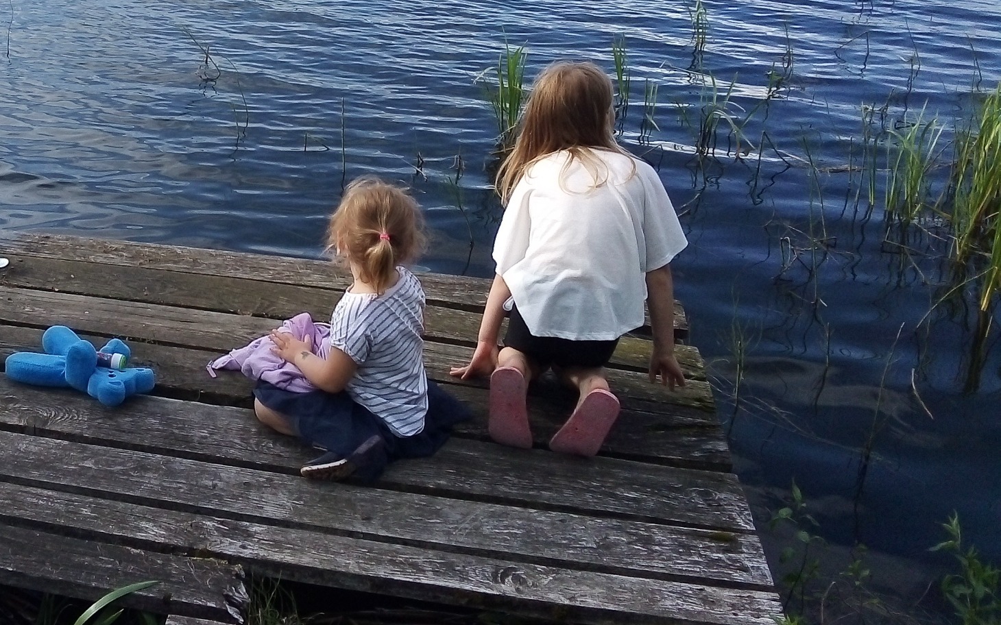 
        Dzieci bawiące się na pomoście nad wodą.
    