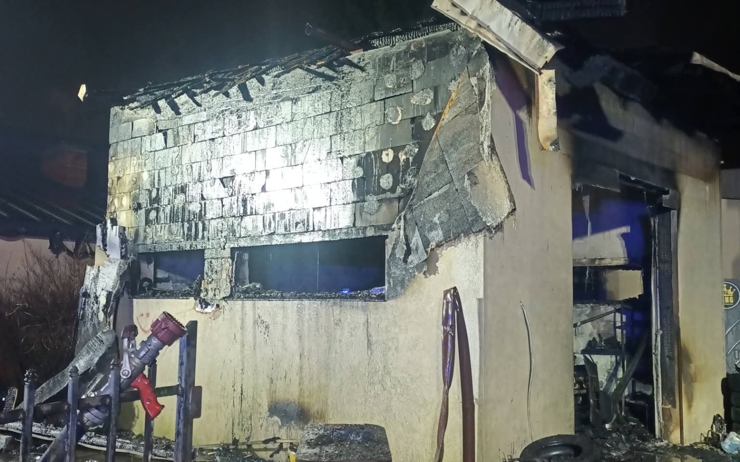 
        Zniszczony budynek po pożarze, z uszkodzoną elewacją.
    