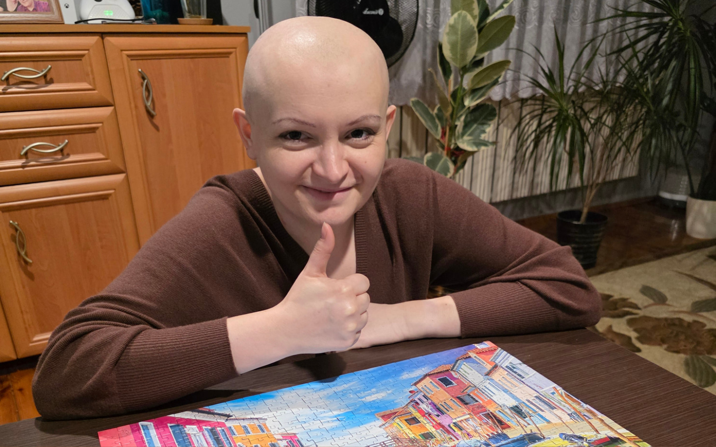 
        Młoda dziewczyna z uśmiechem, trzymająca układankę po zakończeniu.
    