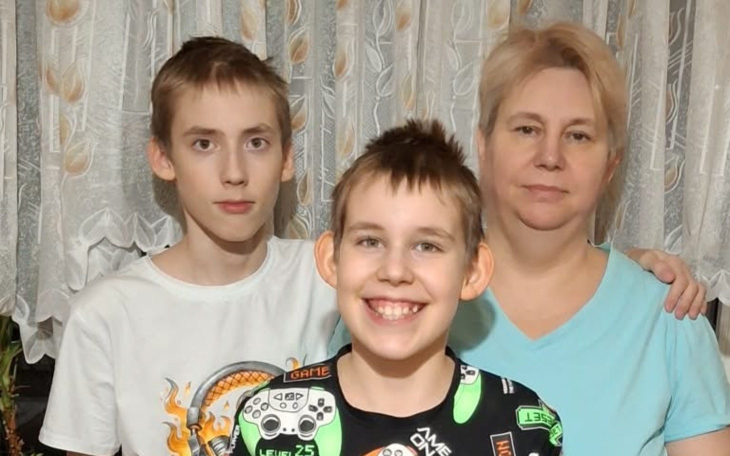 
        Rodzina pozująca razem w domu, uśmiechnięte twarze.
    