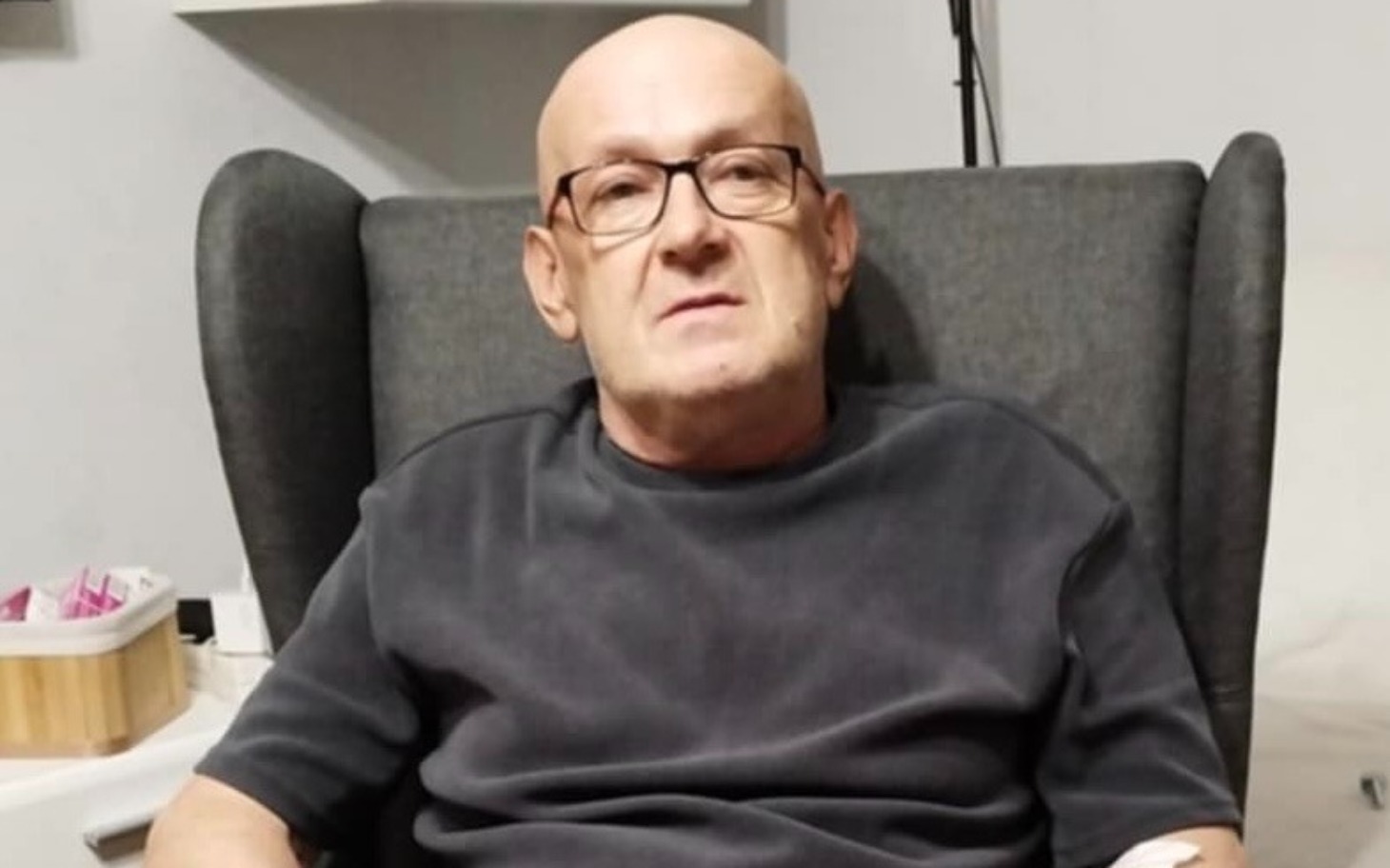 
        Mężczyzna siedzący w fotelu, wygląda na zamyślonego.
    