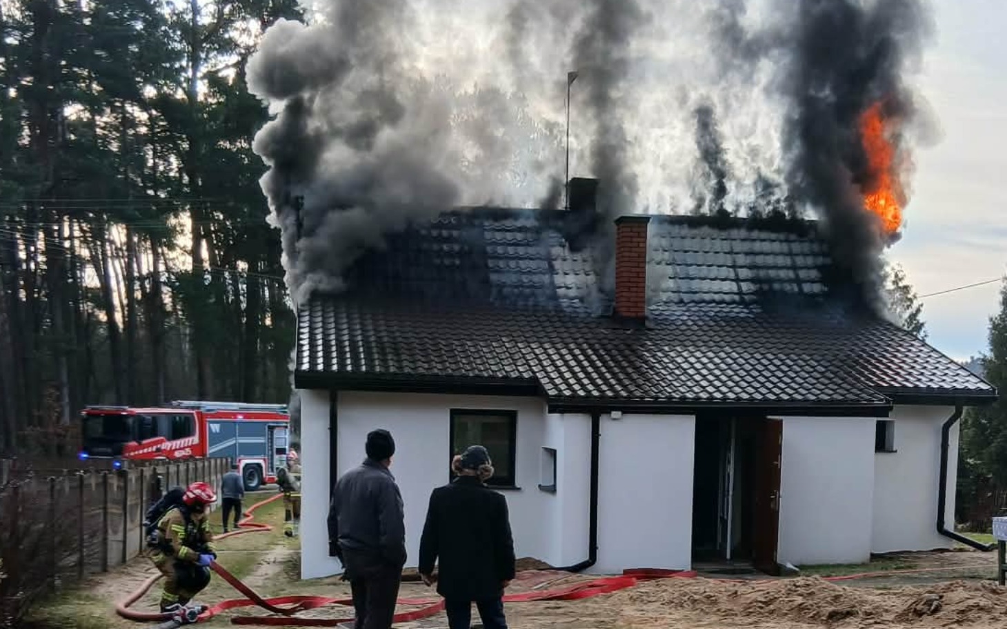 
        Dom w płomieniach, strażacy walczą z pożarem.
    