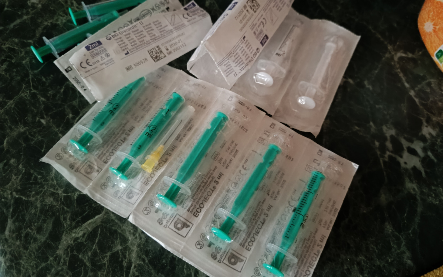 
        Zestaw strzykawek i materiałów medycznych na stole.
    