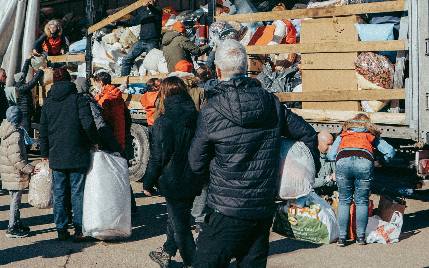 
        Ludzie pomagają przy załadunku darów na ciężarówkę.
    